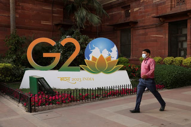 <p>FILE PHOTO: A man walks past a model of G20 logo outside the finance ministry in New Delhi, India, March 1, 2023.</p>
