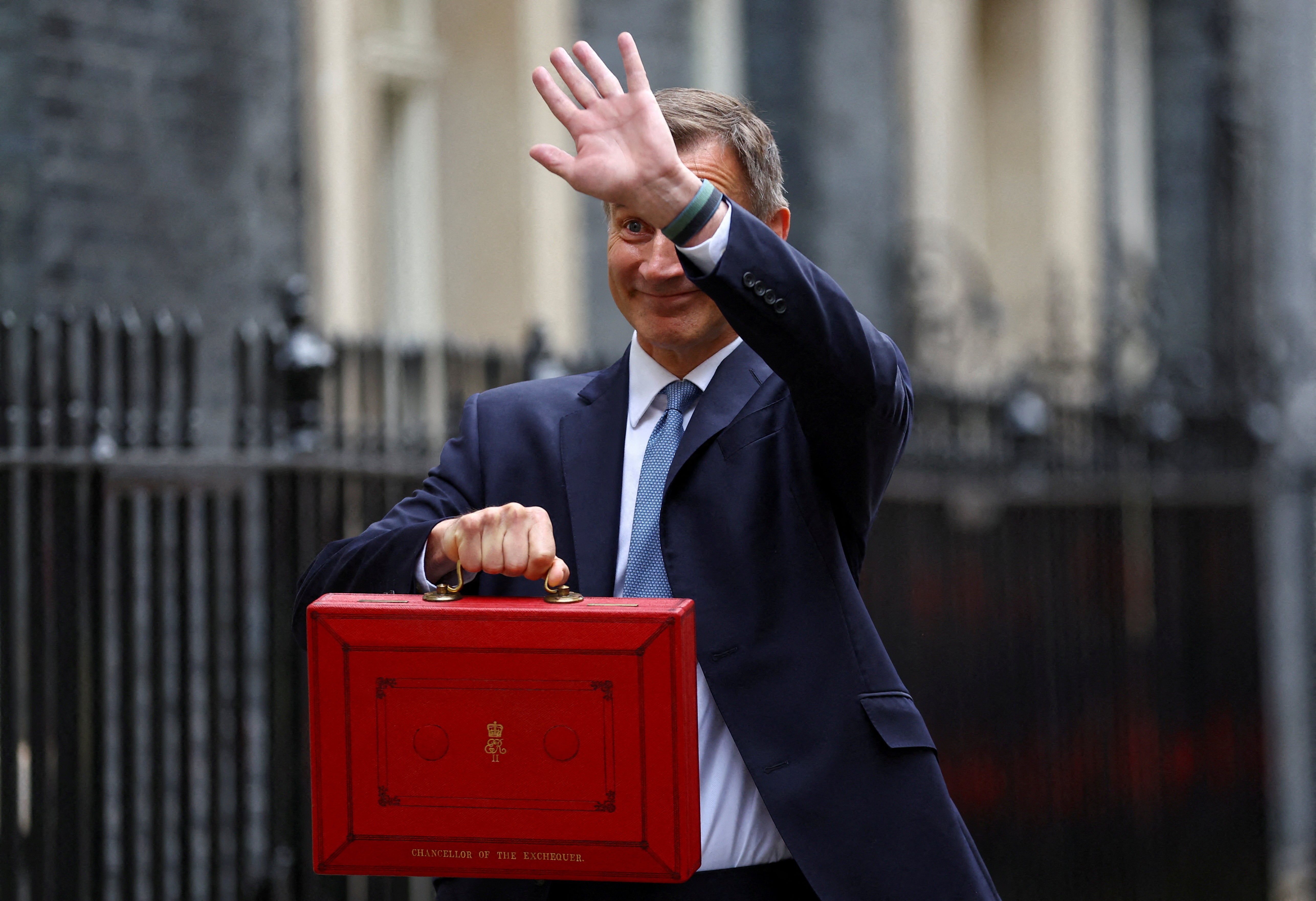 Britain’s Chancellor of the Exchequer Jeremy Hunt gestures as he poses with the budget box at Downing Street