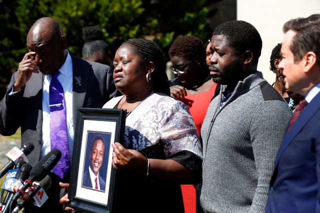 <p>Caroline Ouko, mother of Irvo Otieno, holds a portrait of her son with attorney Ben Crump, left, her older son, Leon Ochieng and attorney Mark Krudys at the Dinwiddie Courthouse in Dinwiddie, Virginia </p>