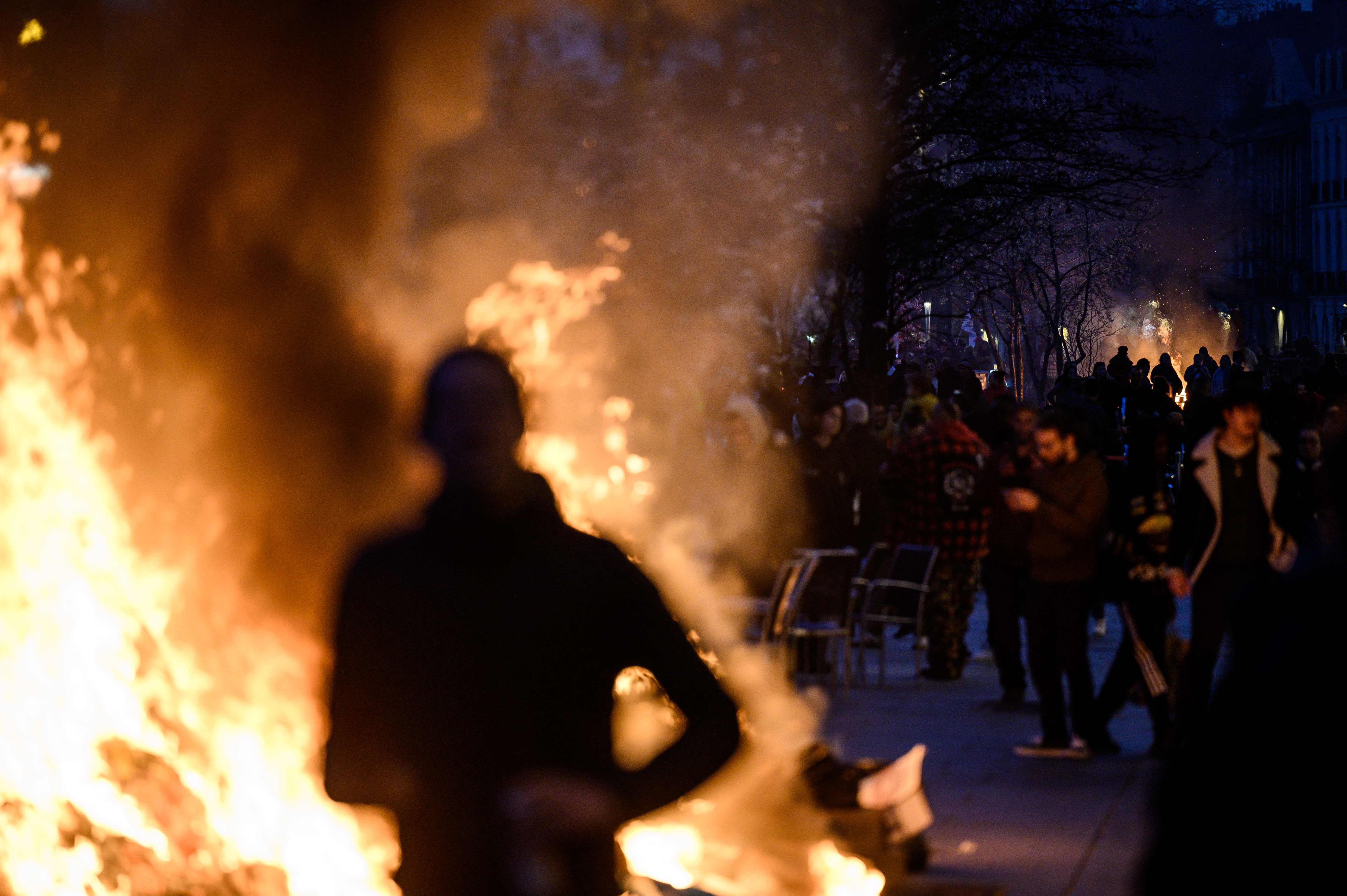 A protester is silhouetted by a bonfire during a demonstration