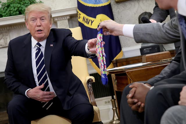 <p>U.S. President Donald Trump receives a pair of socks as a gift while speaking with American workers in the Oval Office about the recently passed tax reform package on January 31, 2018 in Washington, DC</p>