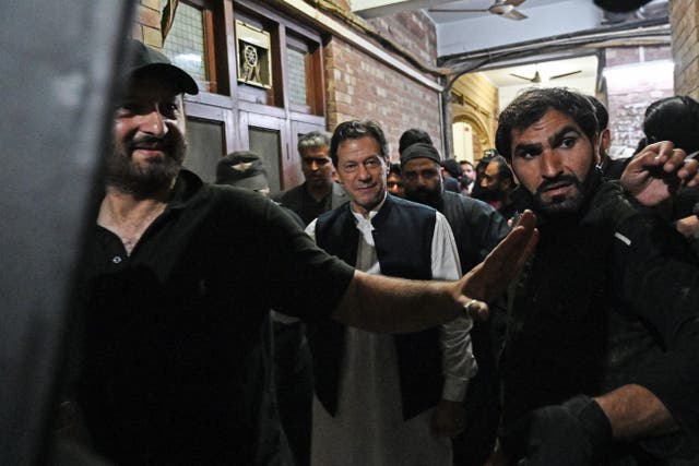 <p>Security personnel use a bullet proof shield to protect Pakistan’s former prime minister Imran Khan as he leaves after appearing at the high court in Lahore</p>