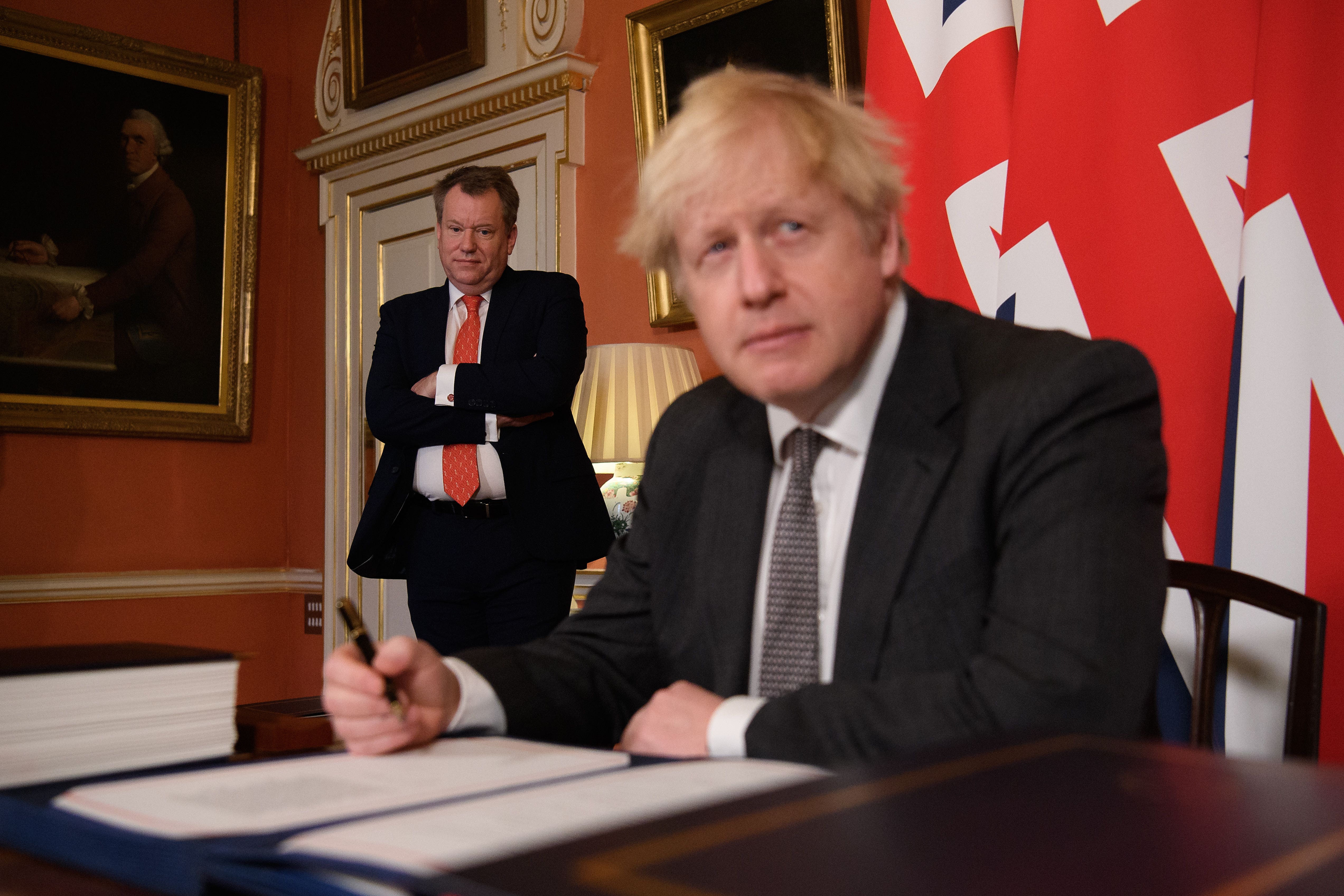 Boris Johnson signs the EU-UK Trade and Co-operation Agreement at 10 Downing Street as UK chief trade negotiator David Frost looks on