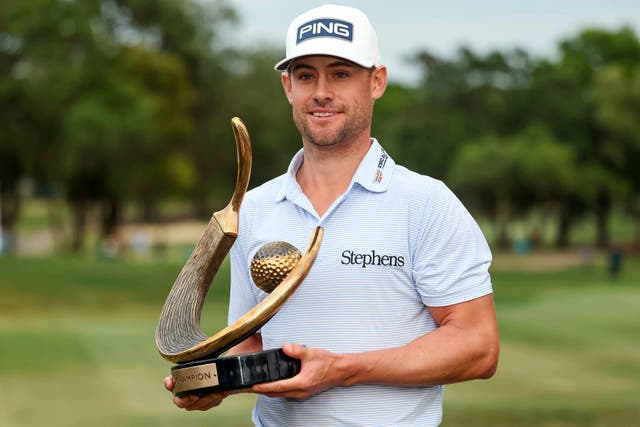Taylor Moore holds the trophy after winning the Valspar Championship (Mike Carlson/AP)