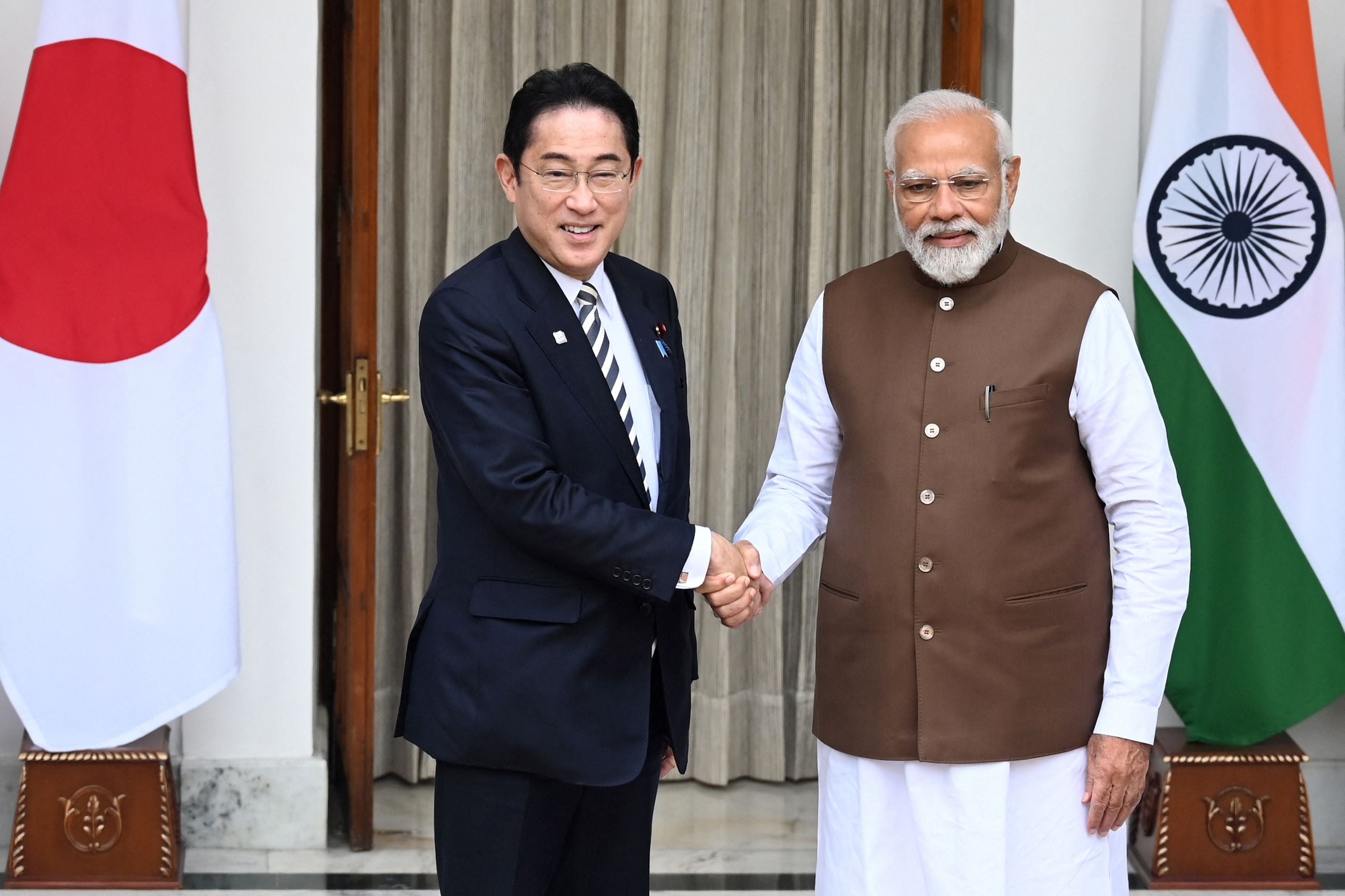 Japan’s Prime Minister Fumio Kishida (left) shakes hands with his Indian counterpart Narendra Modi before their meeting at the Hyderabad House in New Delhi on 20 March