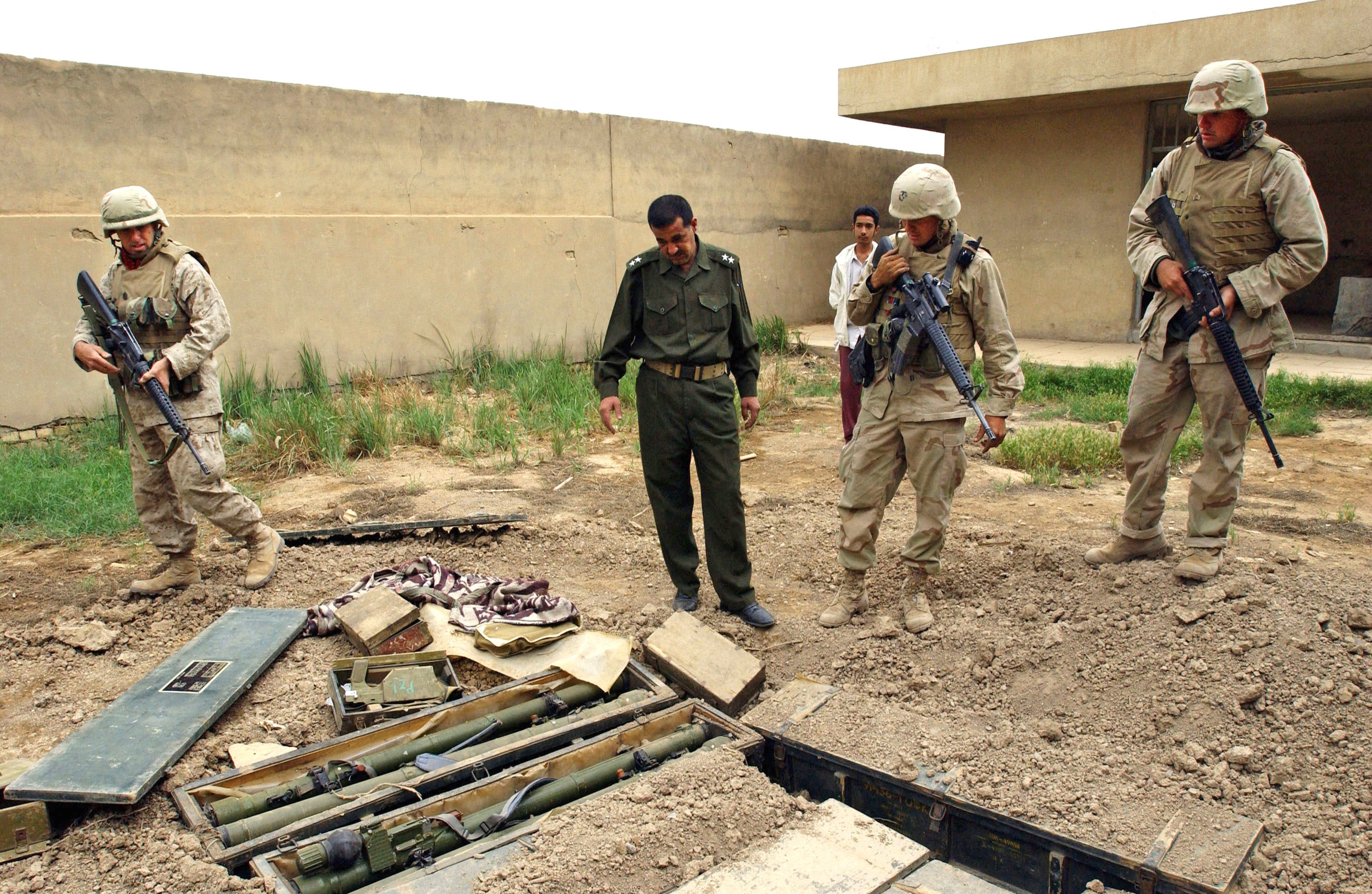 US marines on patrol with Iraqi police officers discover dozens of boxes of Russian made missile launchers hidden in the garden of a school in Baghdad on 16 April, 2003