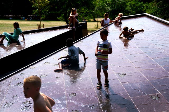 Young children play in the Canada Memorial fountain in Green Park, central London (Victoria Jones/PA)