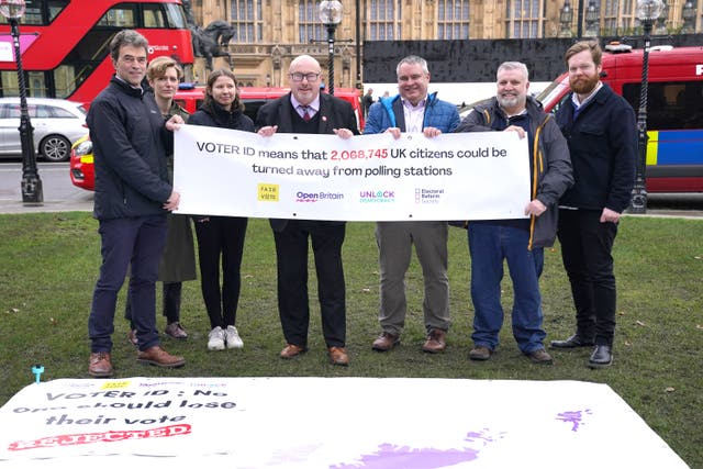 Labour MP Grahame Morris, fourth from left, joins campaigners unveiling a giant map outside the Houses of Parliament in Westminster, London, showing the numbers of voters at risk of being turned away from polling stations because of the voter ID rollout (Jonathan Brady/PA)
