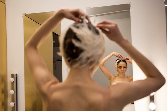 <p>Ganna Muromtseva tries on her headdress after a stage rehearsal</p>