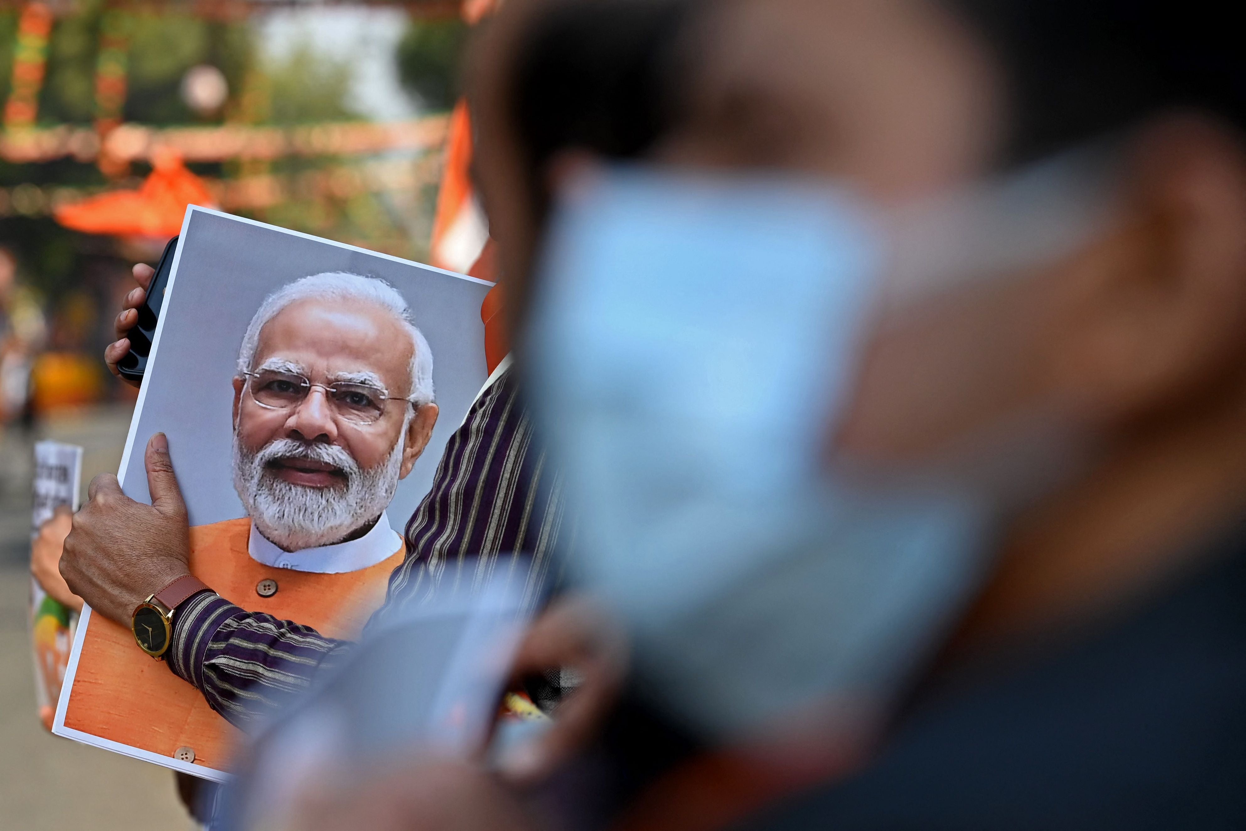A supporter of the Bharatiya Janata Party (BJP) holds a picture of India’s Prime Minister Narendra Modi in New Delhi