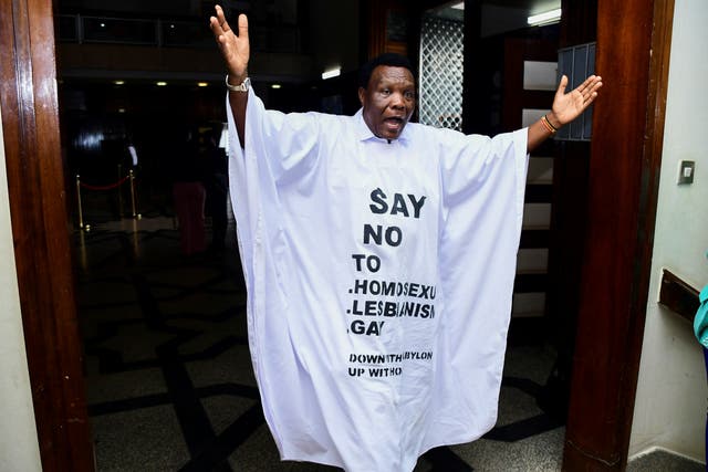 <p>Member of Parliament from Bubulo contituency John Musira dressed in an anti gay gown gestures as he leaves the chambers</p>