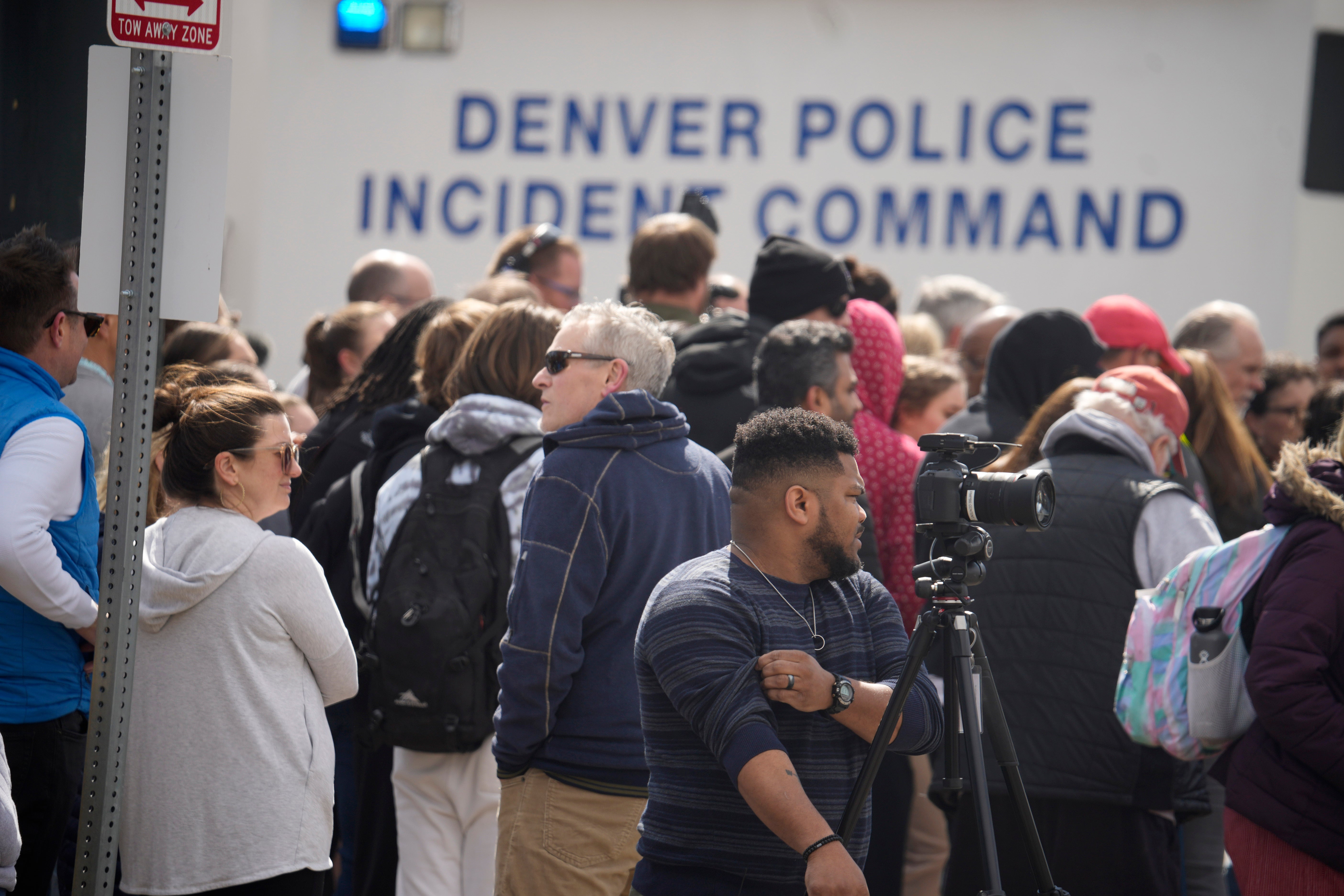 Parents wait for students to be walked out after two administrators shot and wounded after a handgun was found during a daily search of a student at Denver East High School Wednesday, March 22, 2023