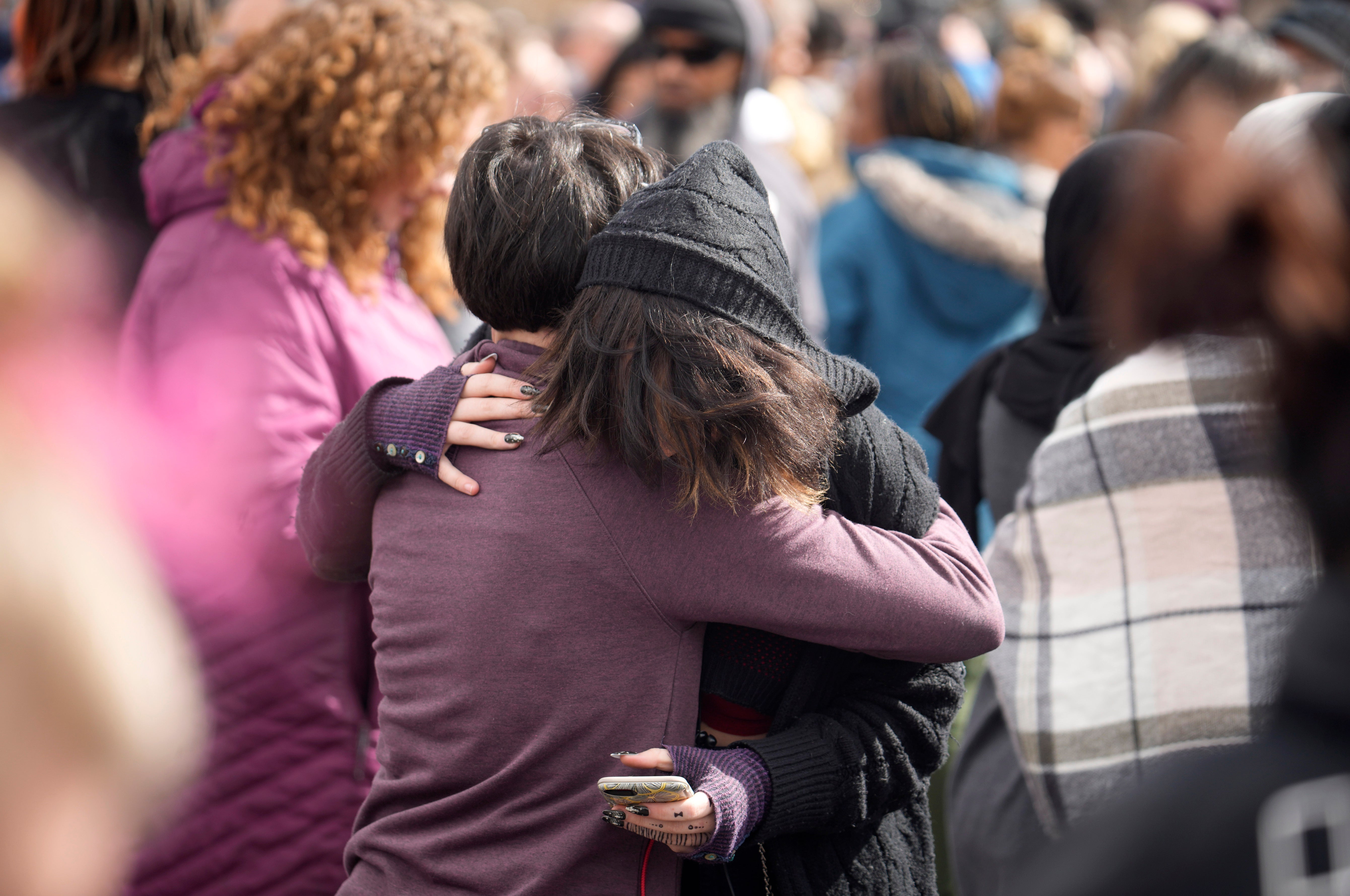 A parent hugs a student as they are reunited after a school shooting at East High School Wednesday, March 22, 2023, in Denver