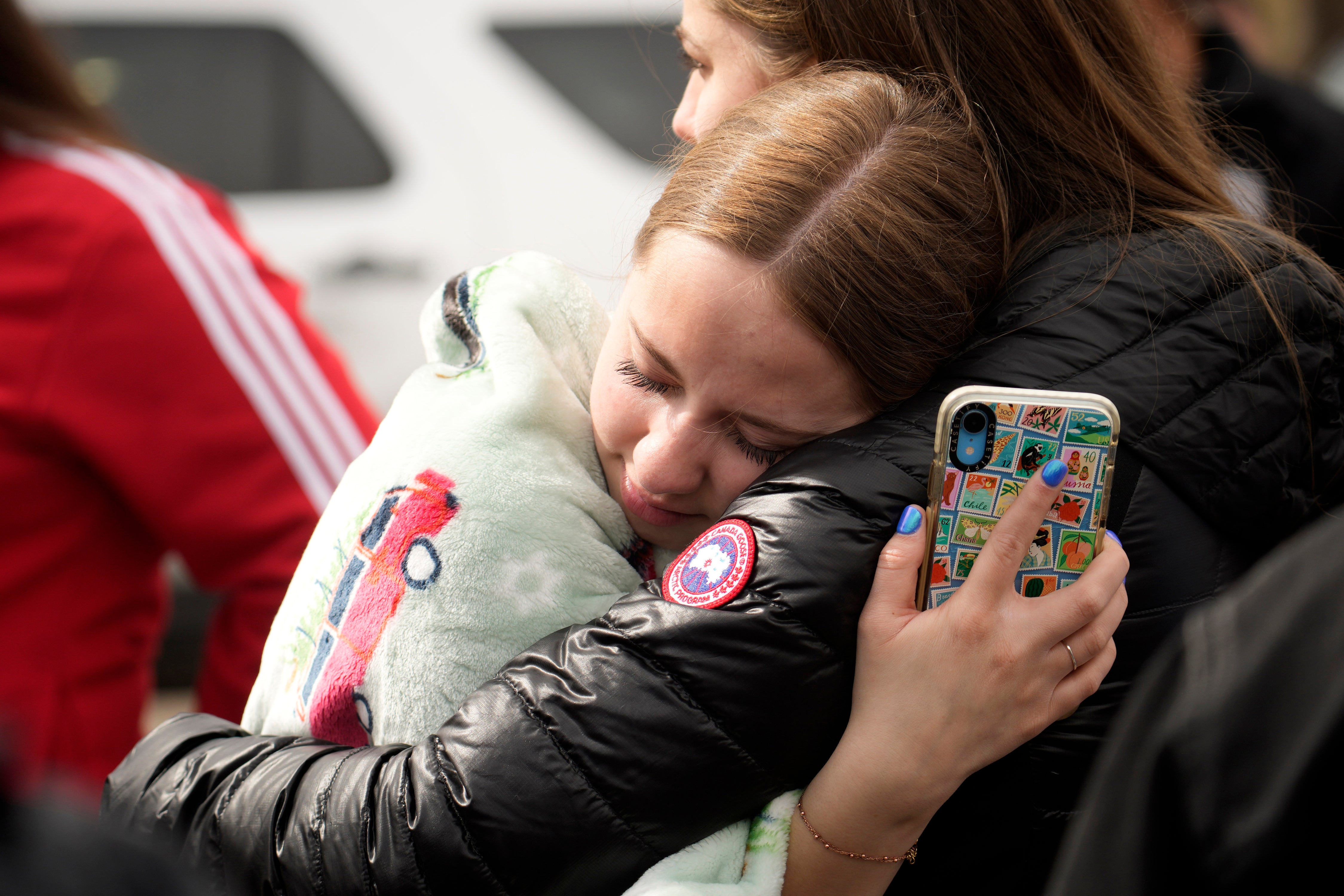 Two women hug when reunited following a shooting at East High School, Wednesday, March 22, 2023, in Denver