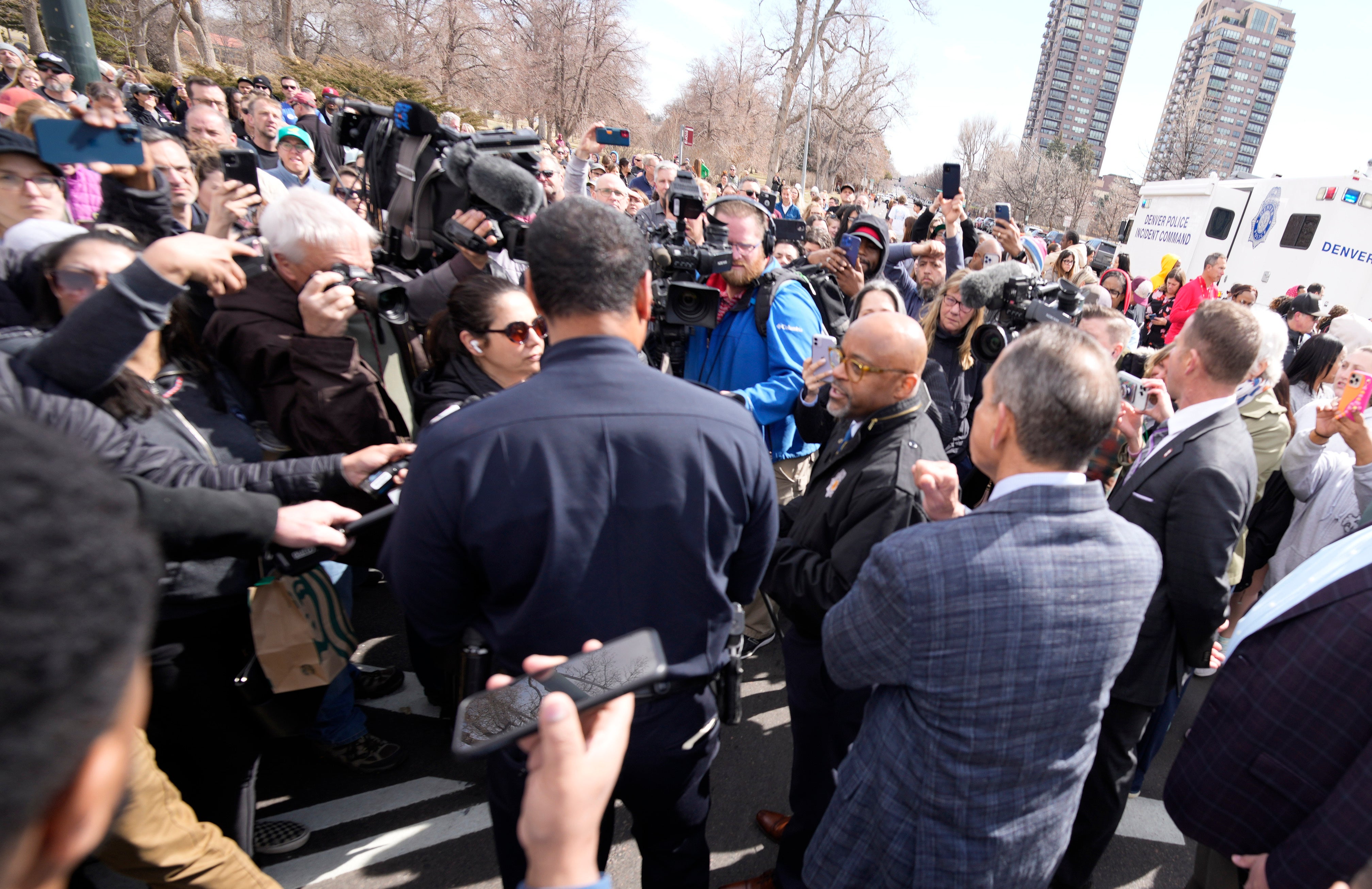 Denver Mayor Michael Hancock, center right, and Chief of Police Ron Thomas, center left, meet with concerned parents as they wait to be reunited with their children following a shooting at East High School, Wednesday, March 22, 2023, in Denver