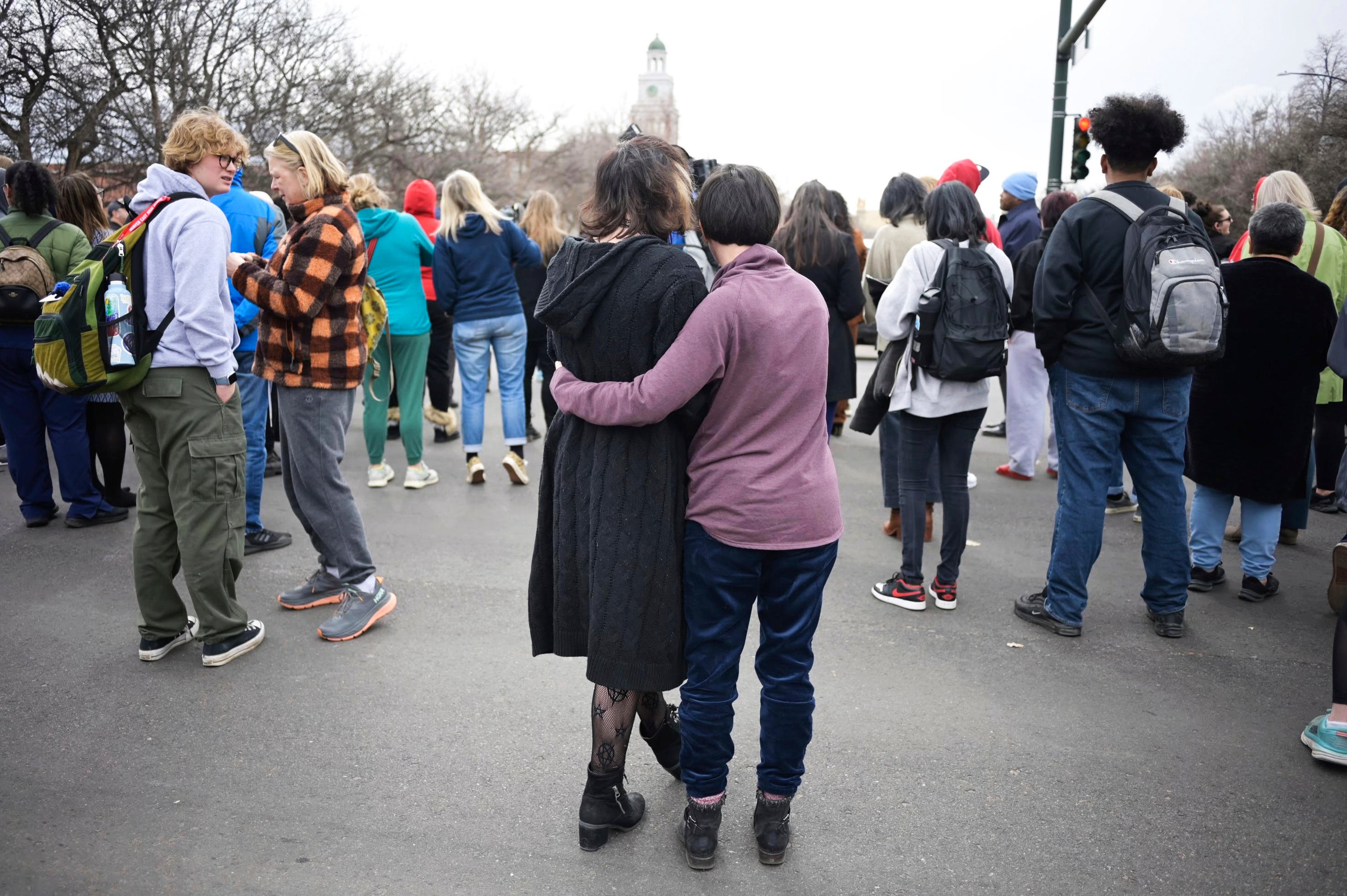 Isabella DeJoseph, 15, center left, is embraced by her mother Alana as they leave East High School after a school shooting, Wednesday, March 22, 2023, in Denver