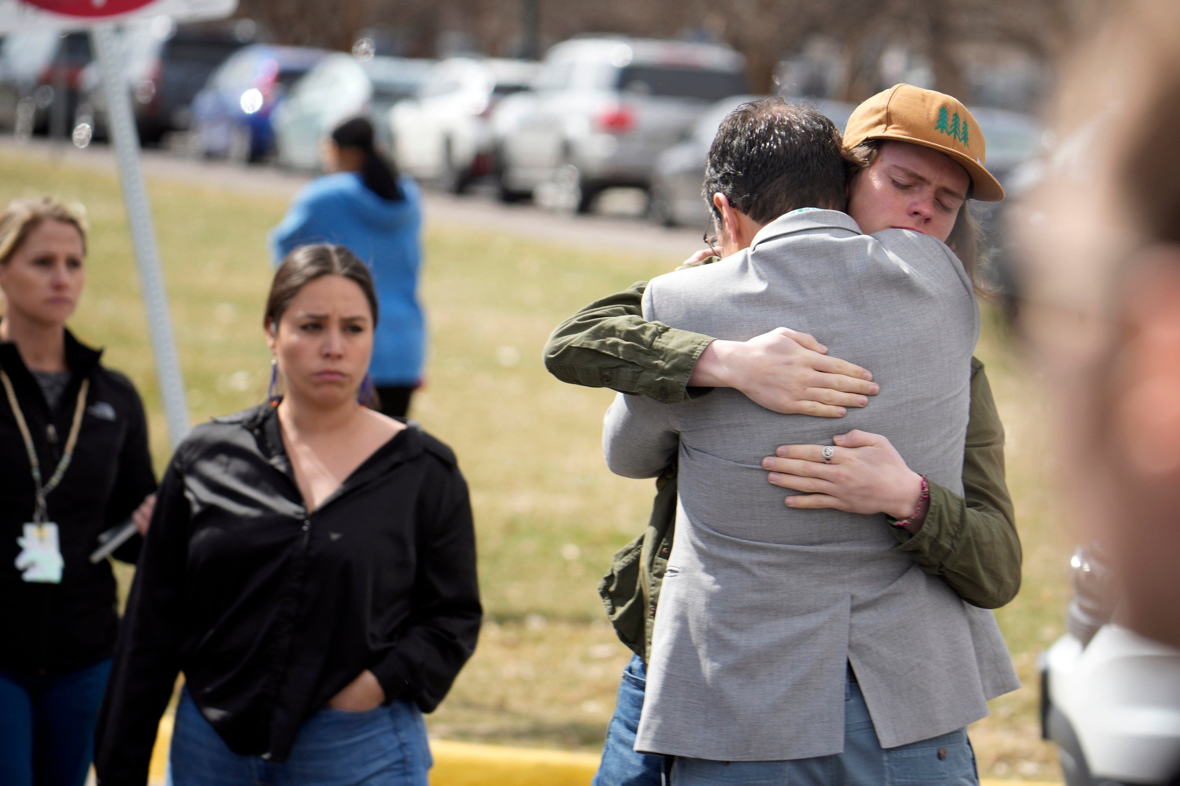 A student, right, hugs a parent as they are reunited following a shooting at East High School, Wednesday, March 22, 2023, in Denver