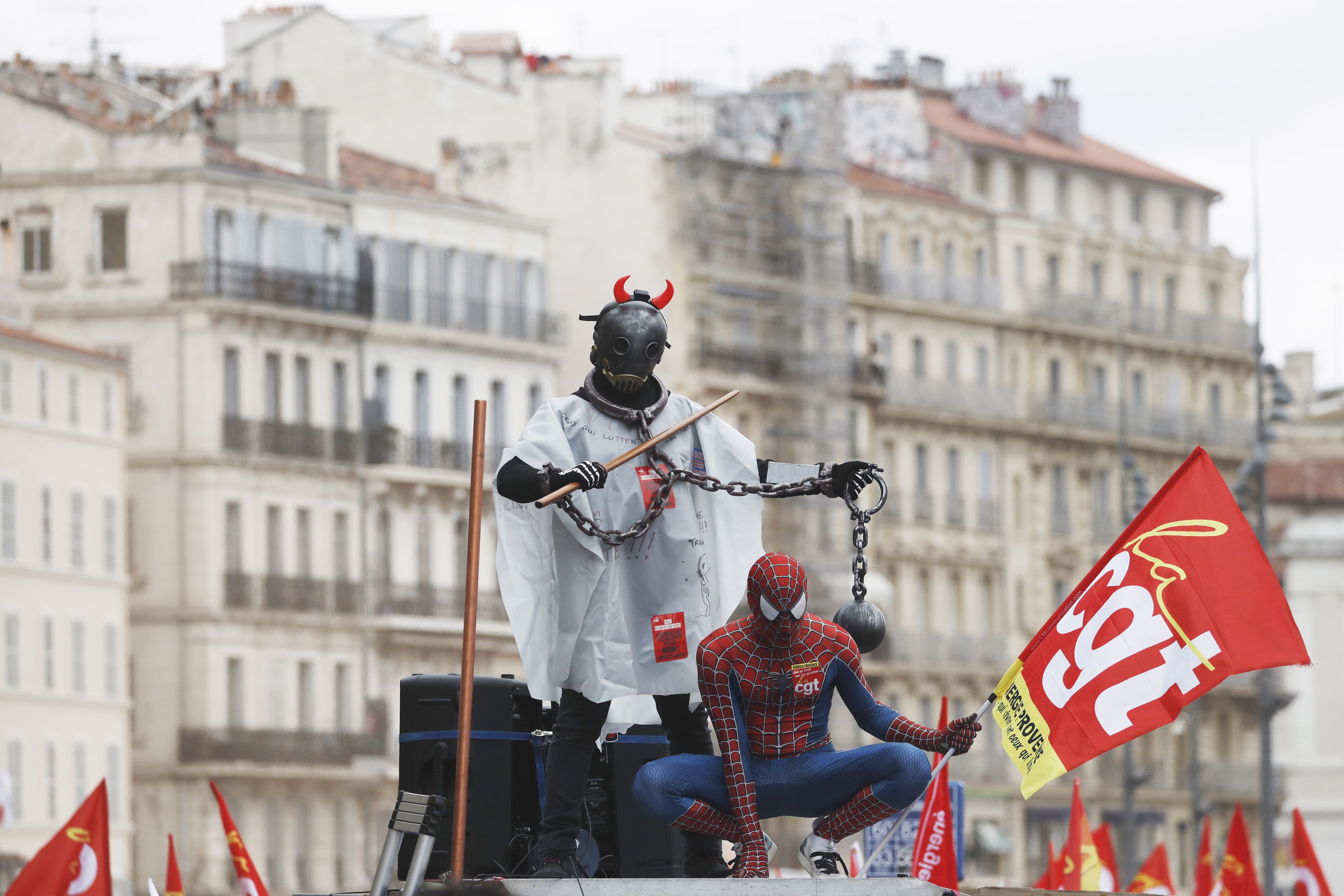 People wear costumes as they ride on a CGT union truck during a rally against the government’s pension reform