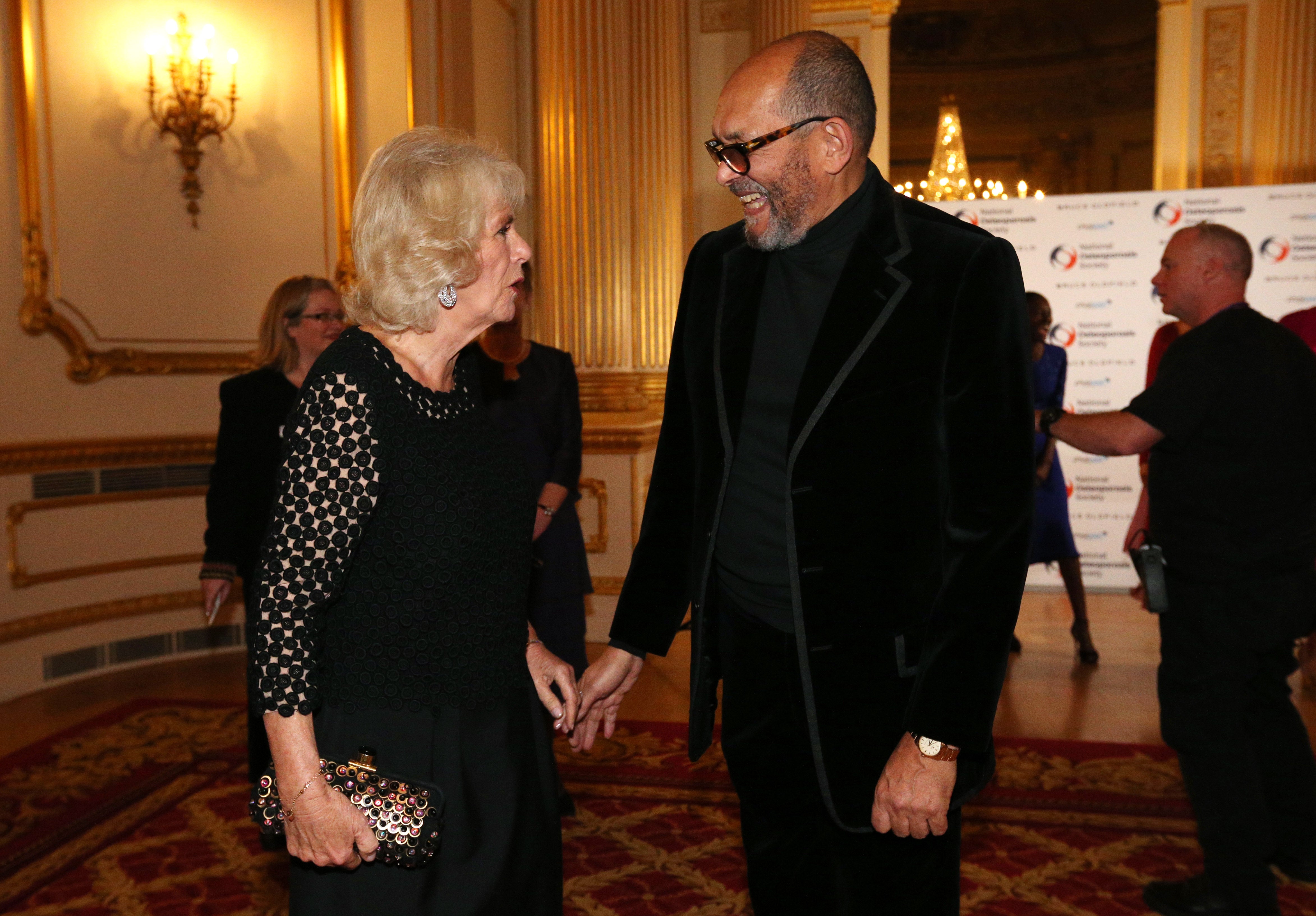 Bruce Oldfield is greeted by Camilla, Duchess of Cornwall during the Bruce Oldfield Fashion Show at Lancaster House in support of the National Osteoporosis Society on November 15, 2017