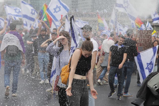 <p>Police use water cannons on protesters blocking the Ayalon Highway in Tel Aviv on Thursday</p>