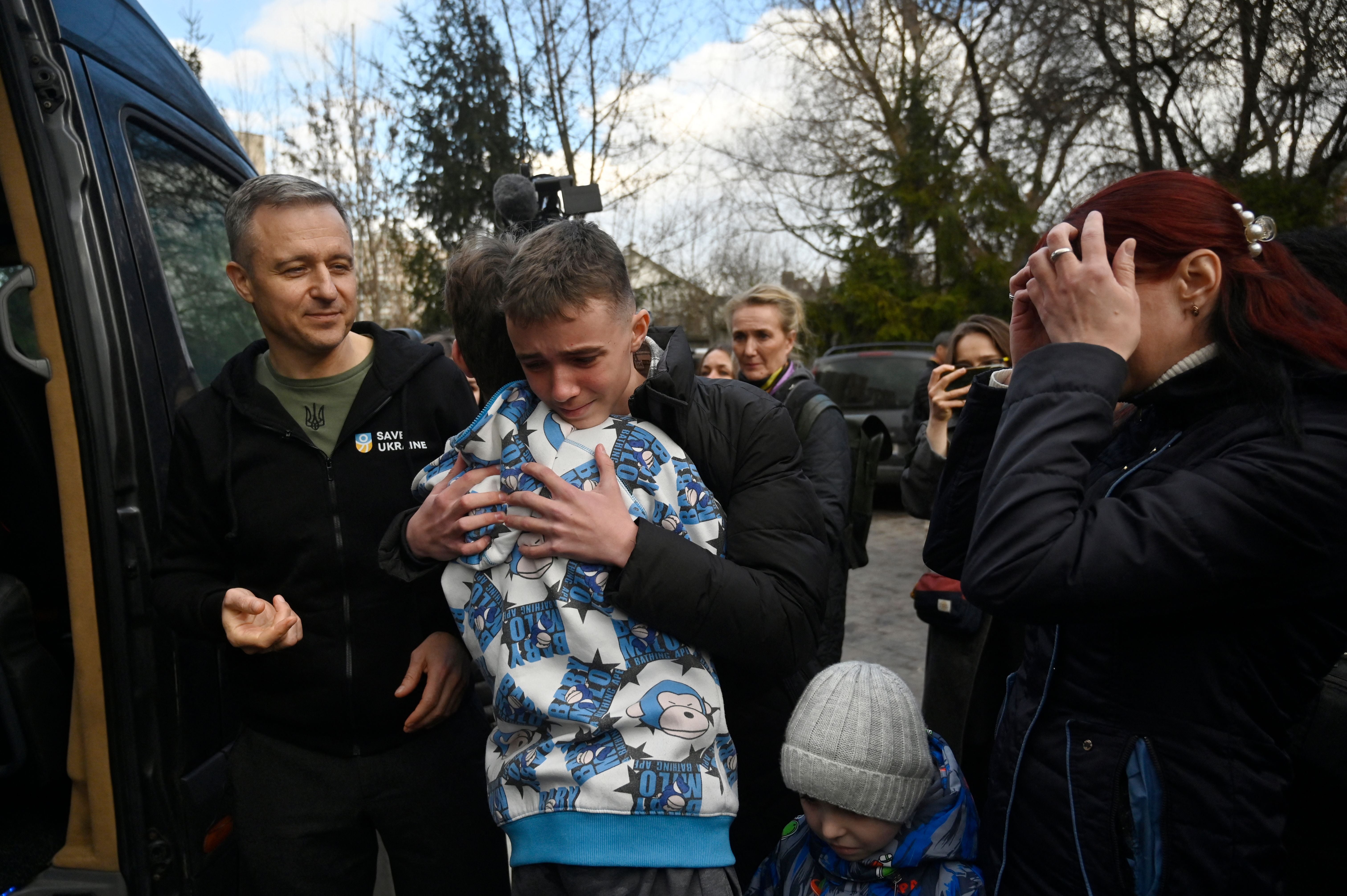 Inessa (right) meets her son Vitaly after the bus delivering him and more than a dozen other children back from Russian-held territory arrived in Kyiv