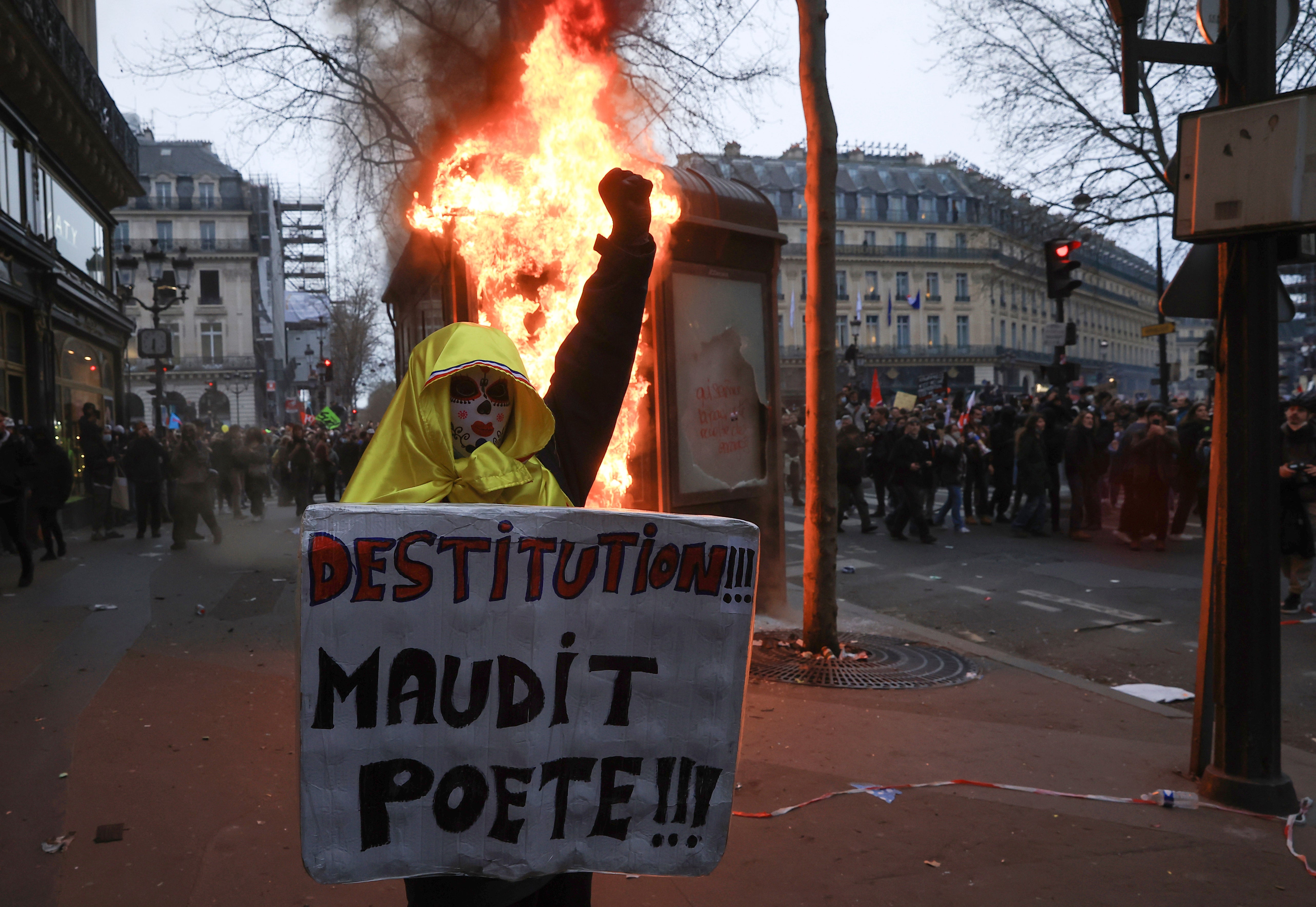 A protester holds a placard that reads ‘destitution of the cursed poet’ during a rally in Paris on Thursday