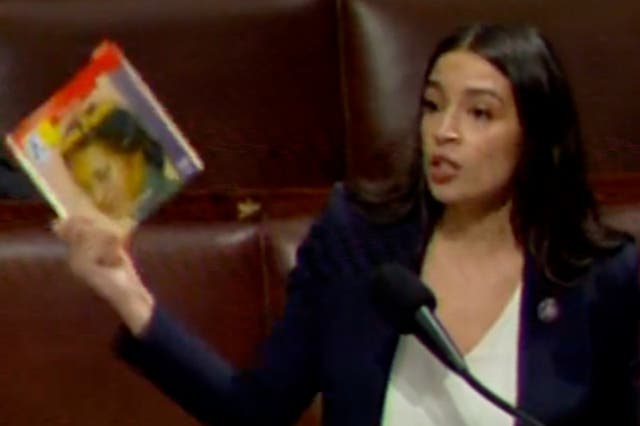 <p>Congresswoman Alexandria Ocasio-Cortez holds up a copy of ‘The Life of Rosa Parks,’ which she said had been banned by a Florida school</p>