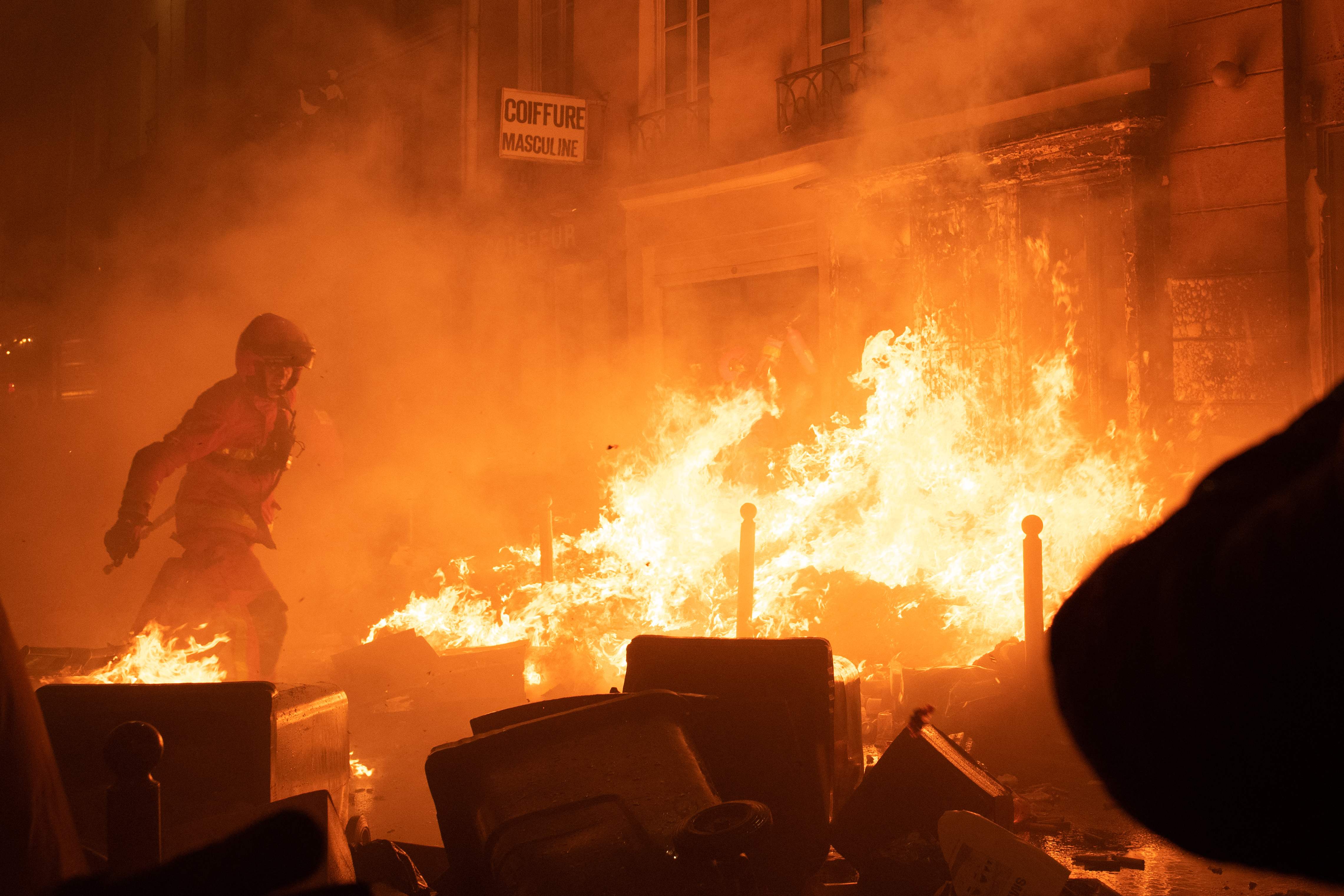 A firefighter in Paris after rioters set uncollected rubbish alight