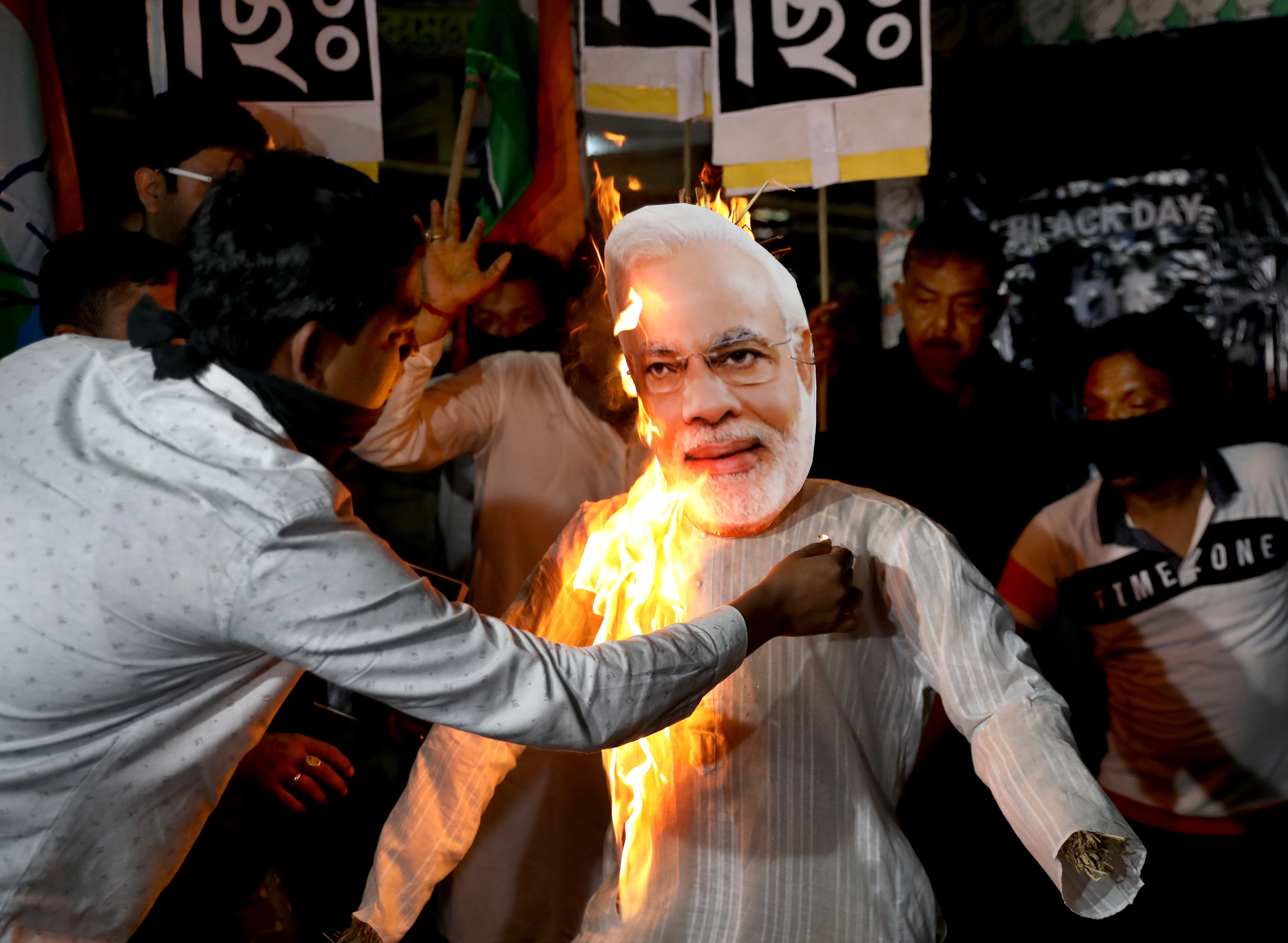Supporters of the opposition Congress Party burn an effigy of Indian prime minister Narendra Modi