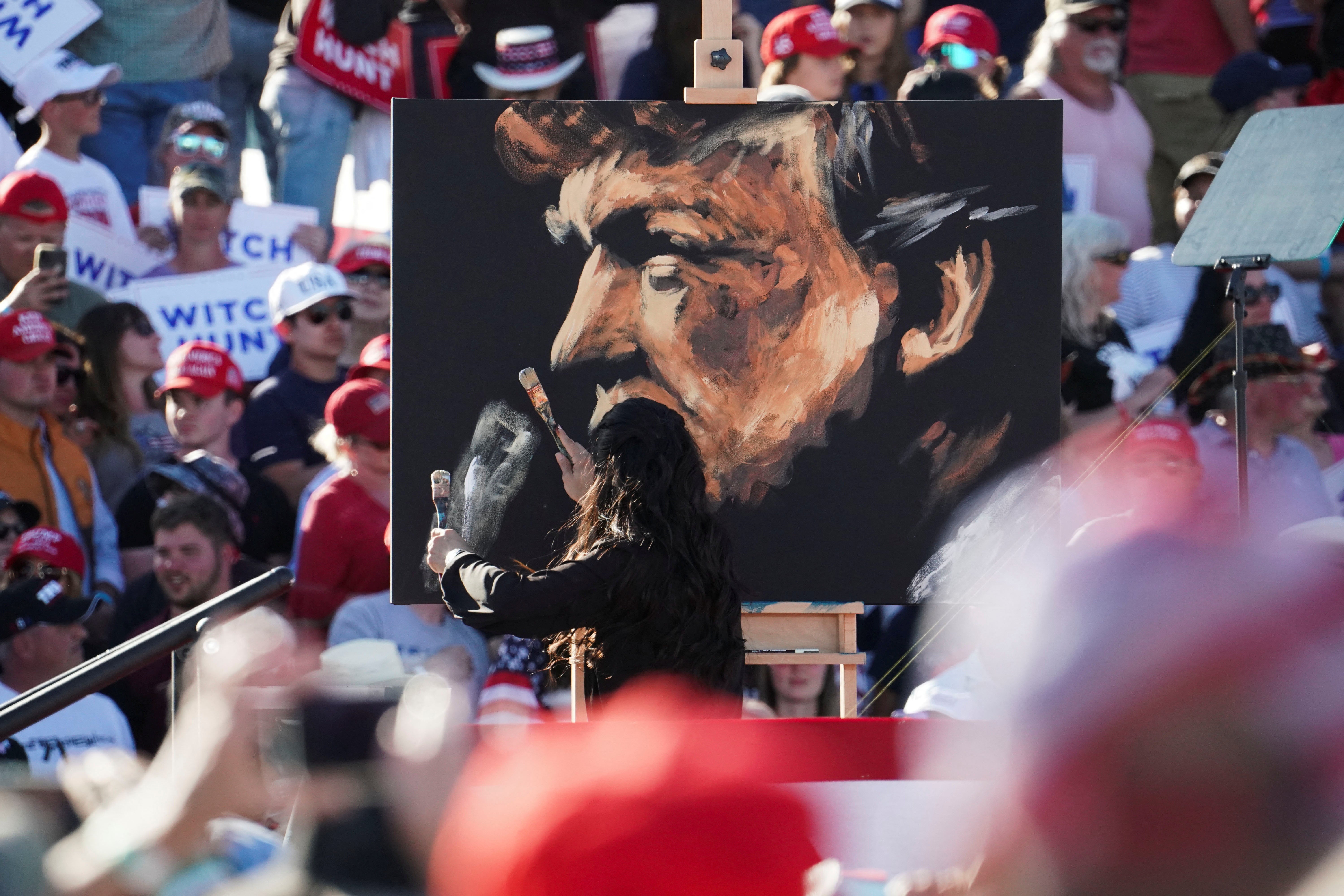 An artist paints a portrait of former Trump before his appearance on stage at Waco
