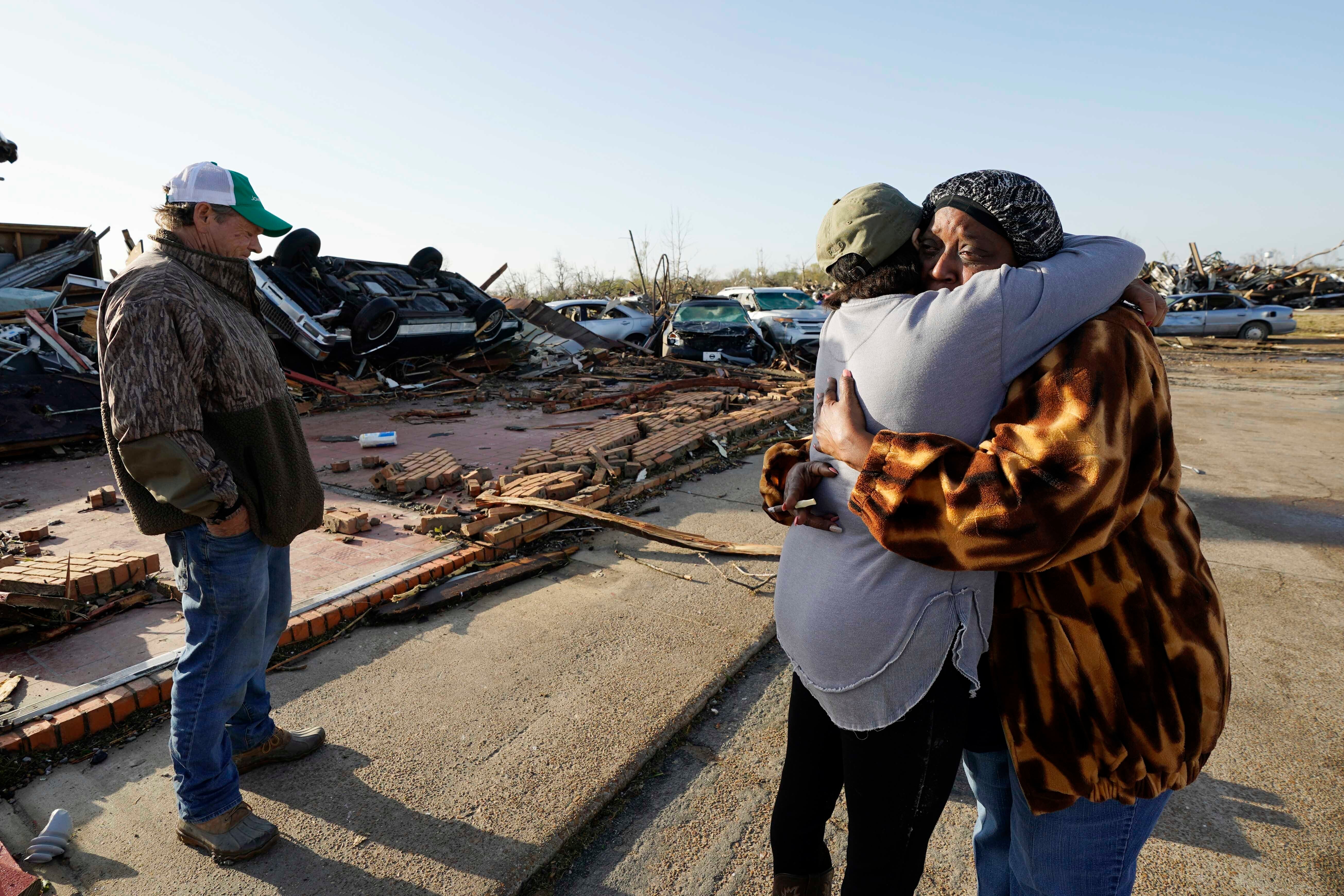 Tracy Hardin, center, who with her husband Tim, left, own Chuck’s Dairy Bar, consoles a neighbor in Rolling Fork, Mississippi