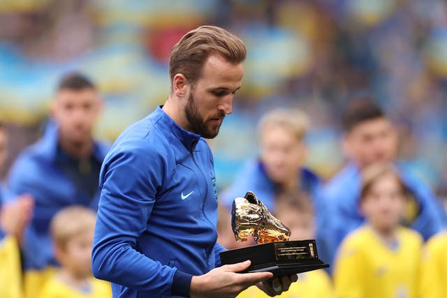 <p>Harry Kane receives a Golden Boot trophy after becoming England’s record scorer</p>