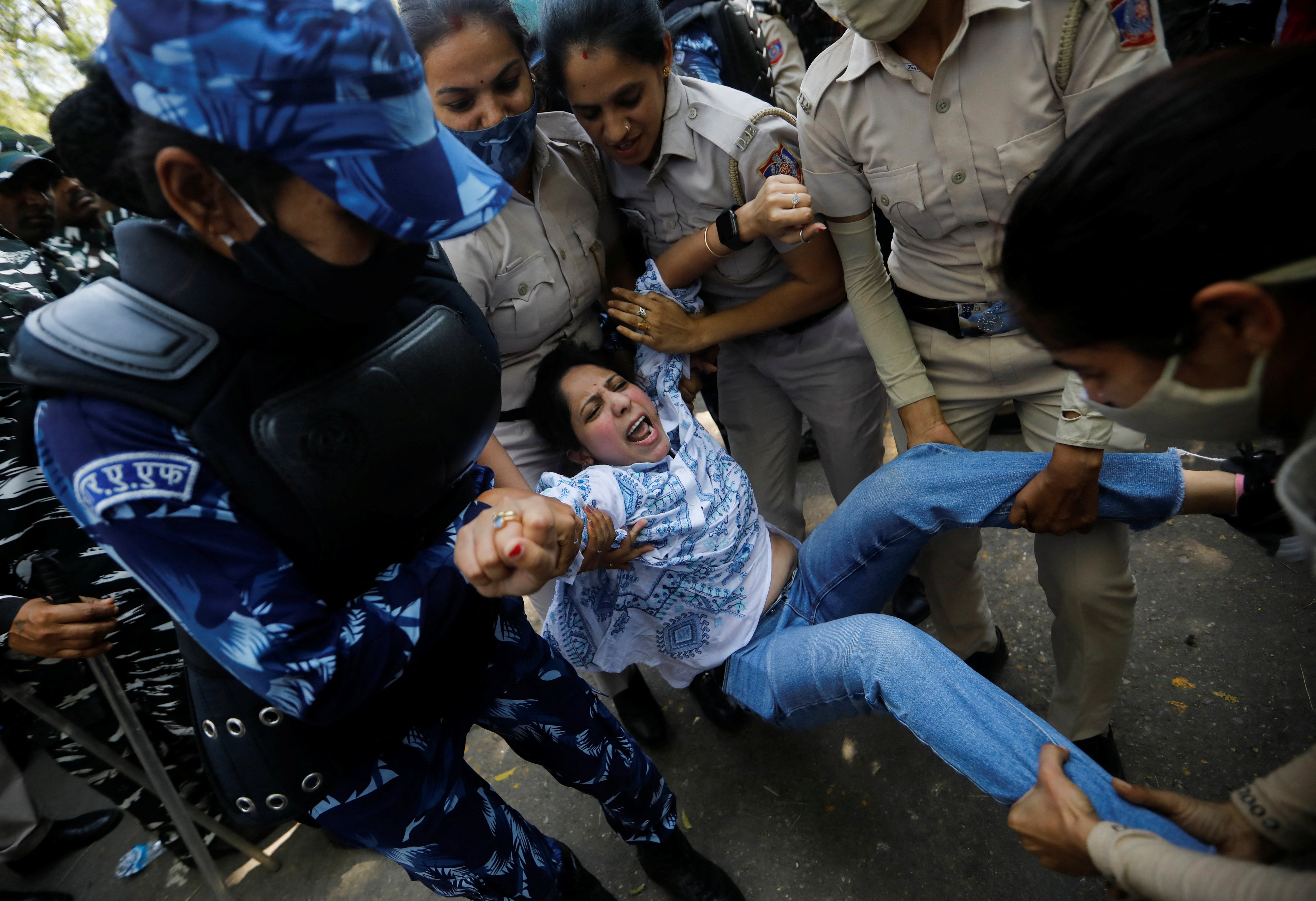 Police officers detain a supporter of India’s main opposition Congress Party on 27 March
