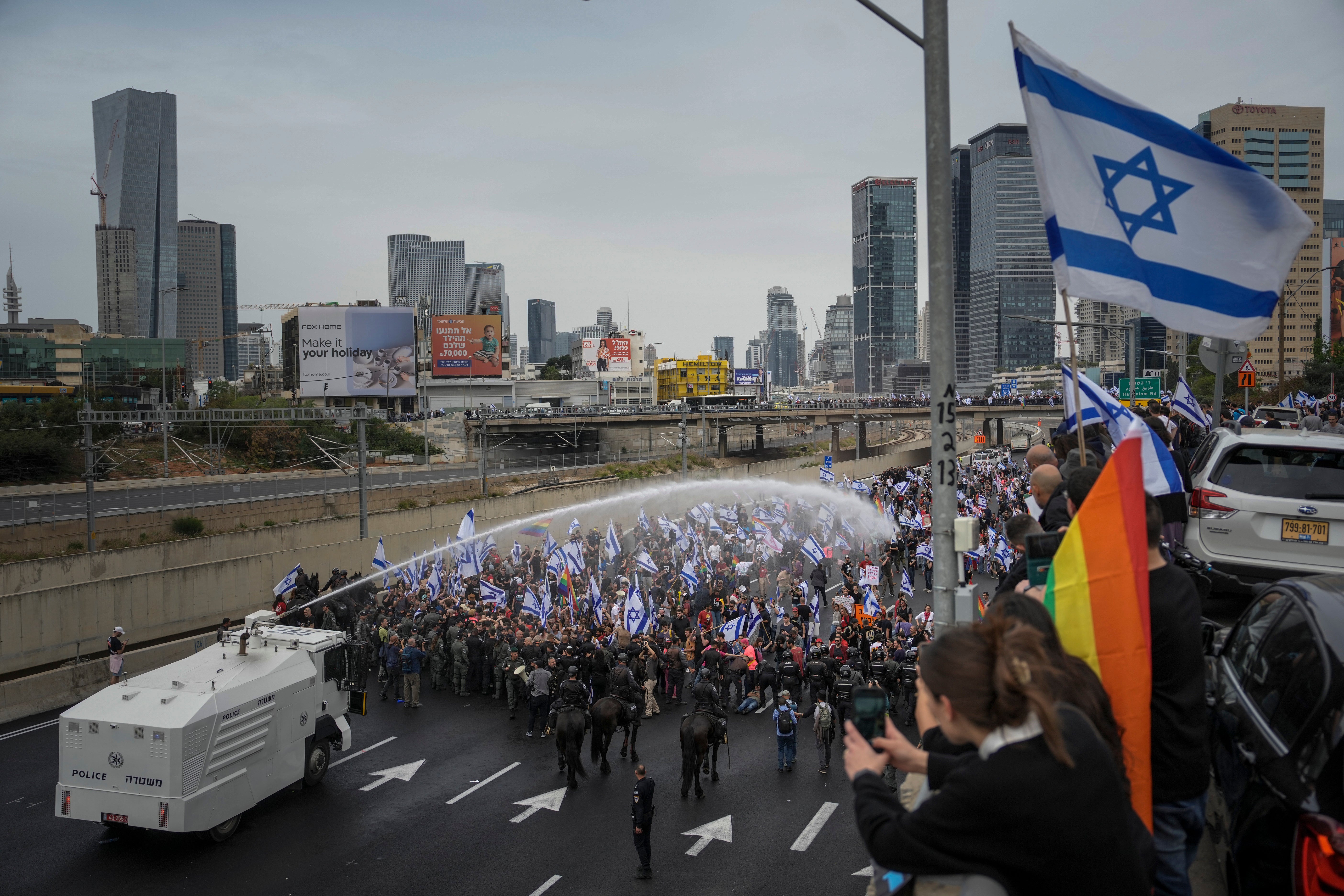 sraeli police use a water cannon to disperse Israelis blocking the freeway during a protest