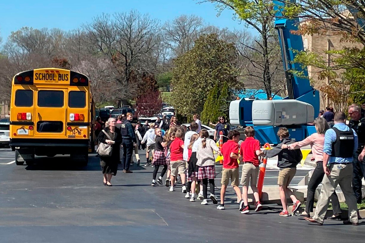 Children from an elementary school in Nashville hold hands as they are moved to a reunification site following a shooting at the school on 27 March.