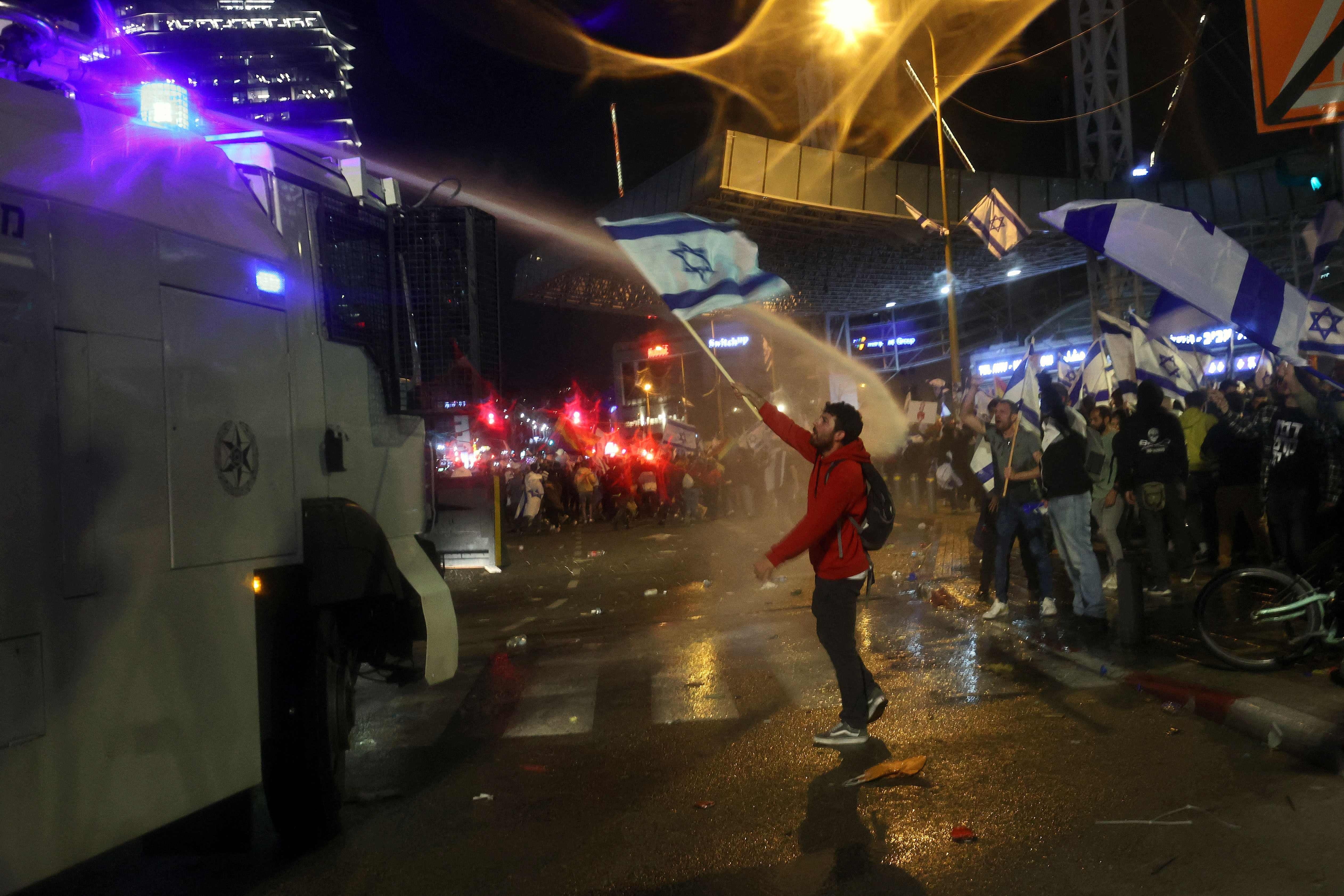 Israeli security forces use water canons to disperse protesters during ongoing demonstrations in Tel Aviv on March 27, 2023