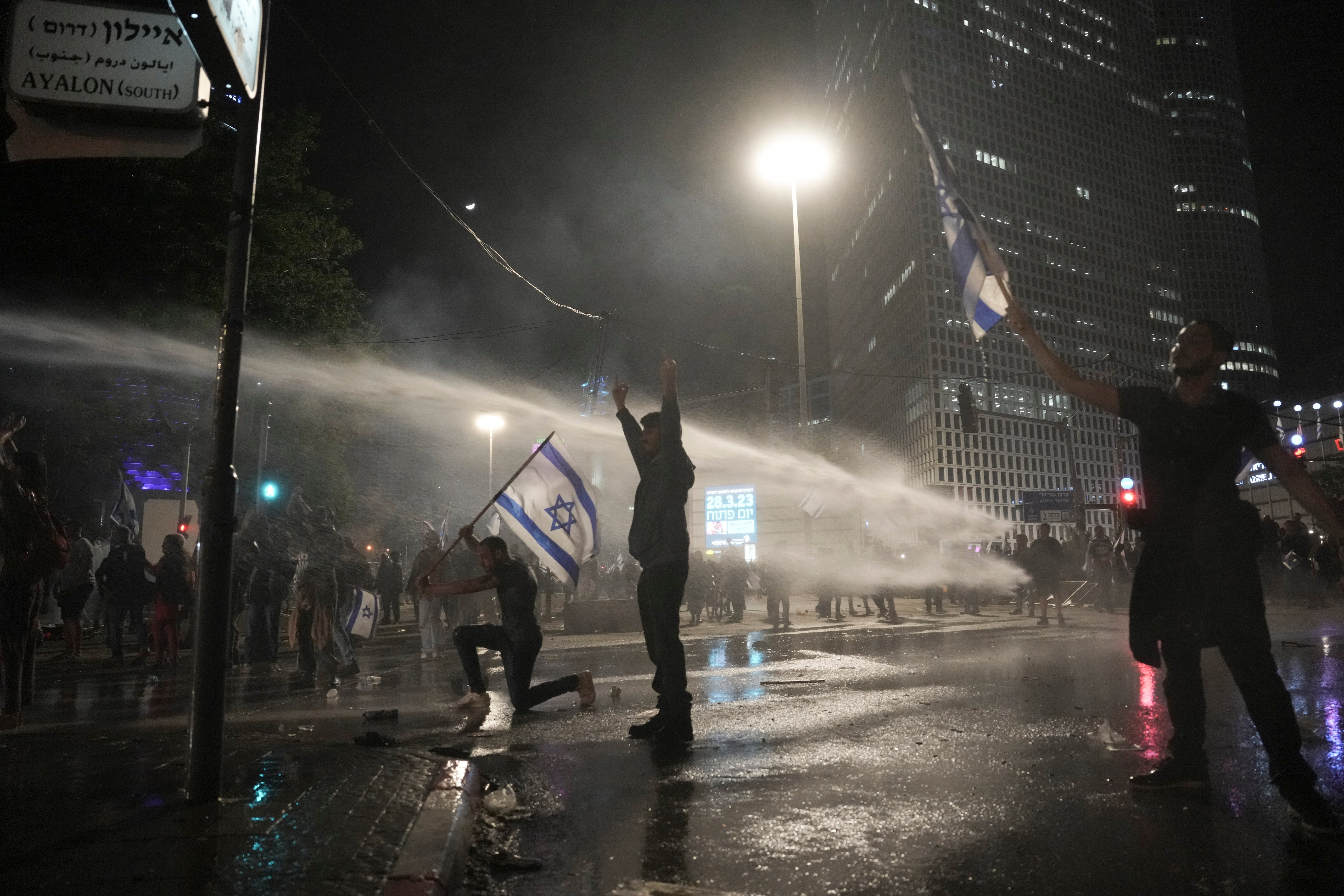 Israeli security forces use water canons to disperse protesters during ongoing demonstrations in Tel Aviv on March 27, 2023