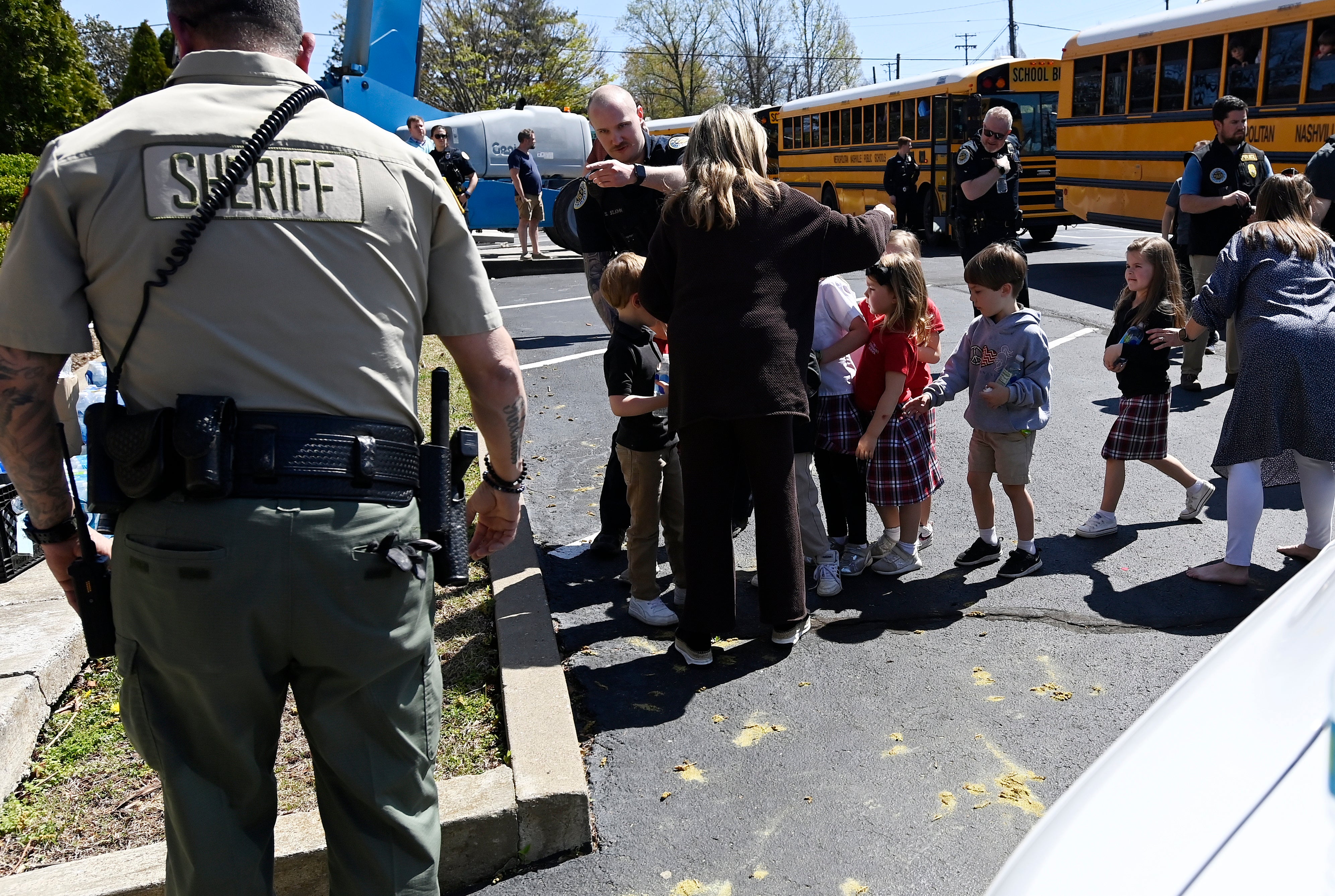 Students from The Covenant School get off a bus to meet their parents at the reunification site at the Woodmont Baptist Church