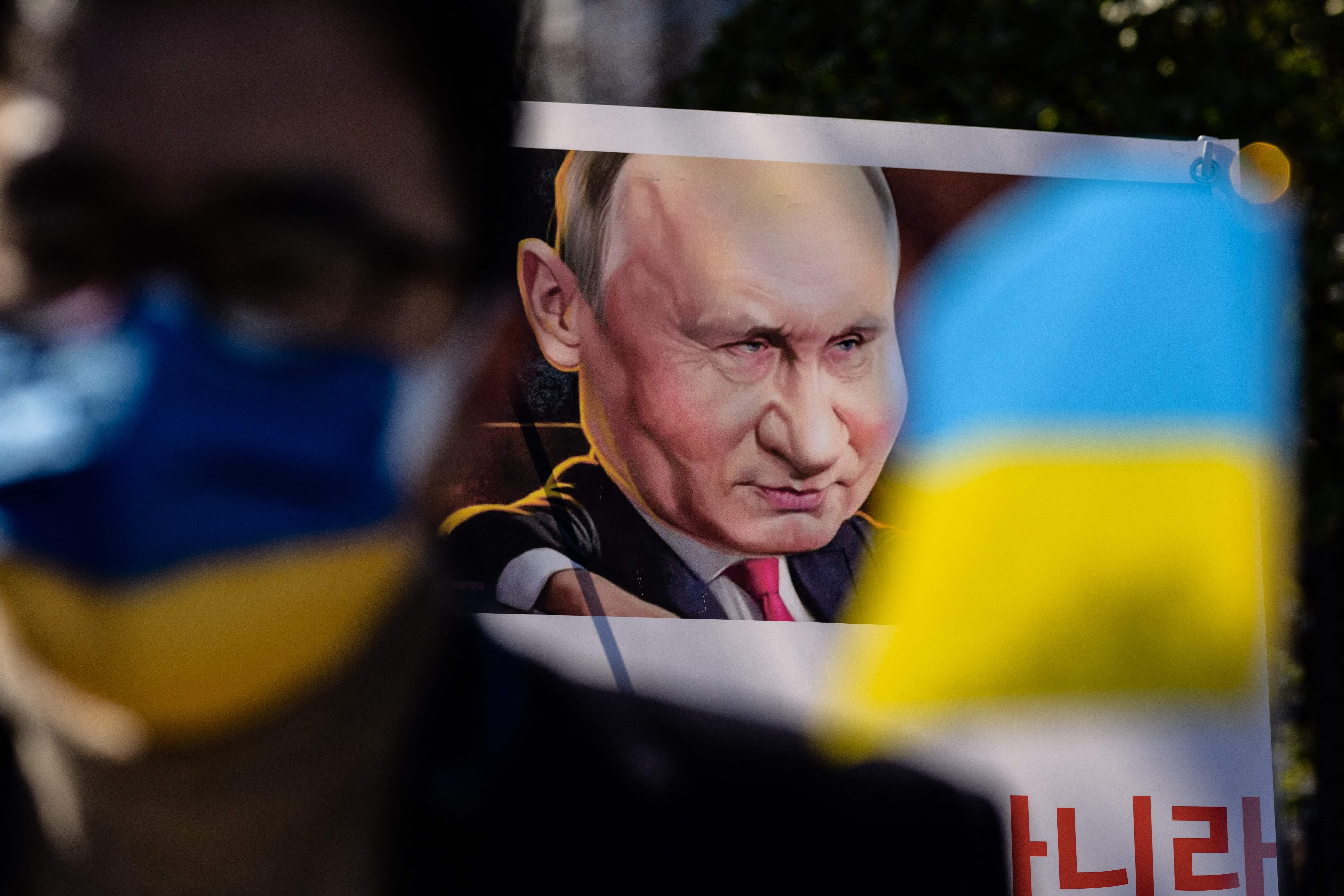 A poster depicting Russian president Vladimir Putin is displayed as people gather during a protest to mark one year since Russia’s invasion of Ukraine, near the Russian embassy in Seoul
