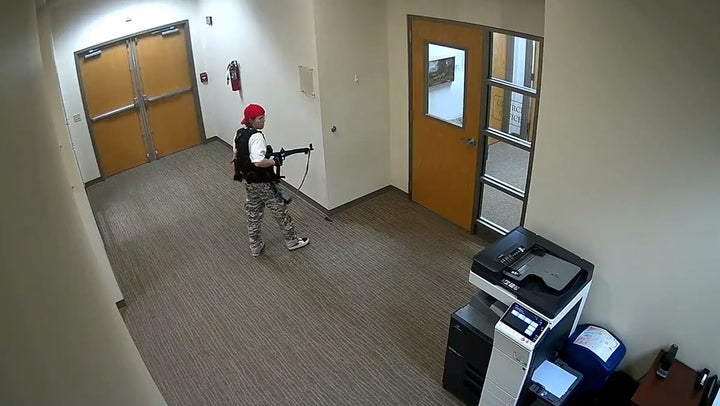 Surveillance footage shows the shooter walking through a school corridor holding a gun