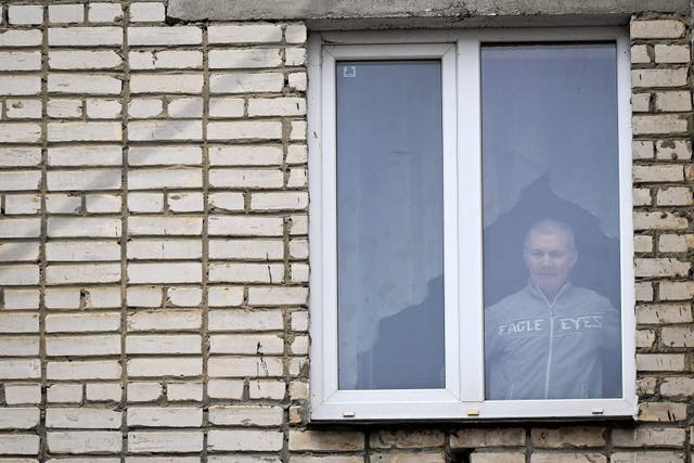 <p>Alexei Moskalyov, 54, a single parent of Maria Moskalyova, the 13-year-old girl who drew a picture critical of Moscow's military campaign in Ukraine at school in April last year, looks out through the window of his flat after he was placed under house for repeating Ukraine posts discrediting the Russian army</p>