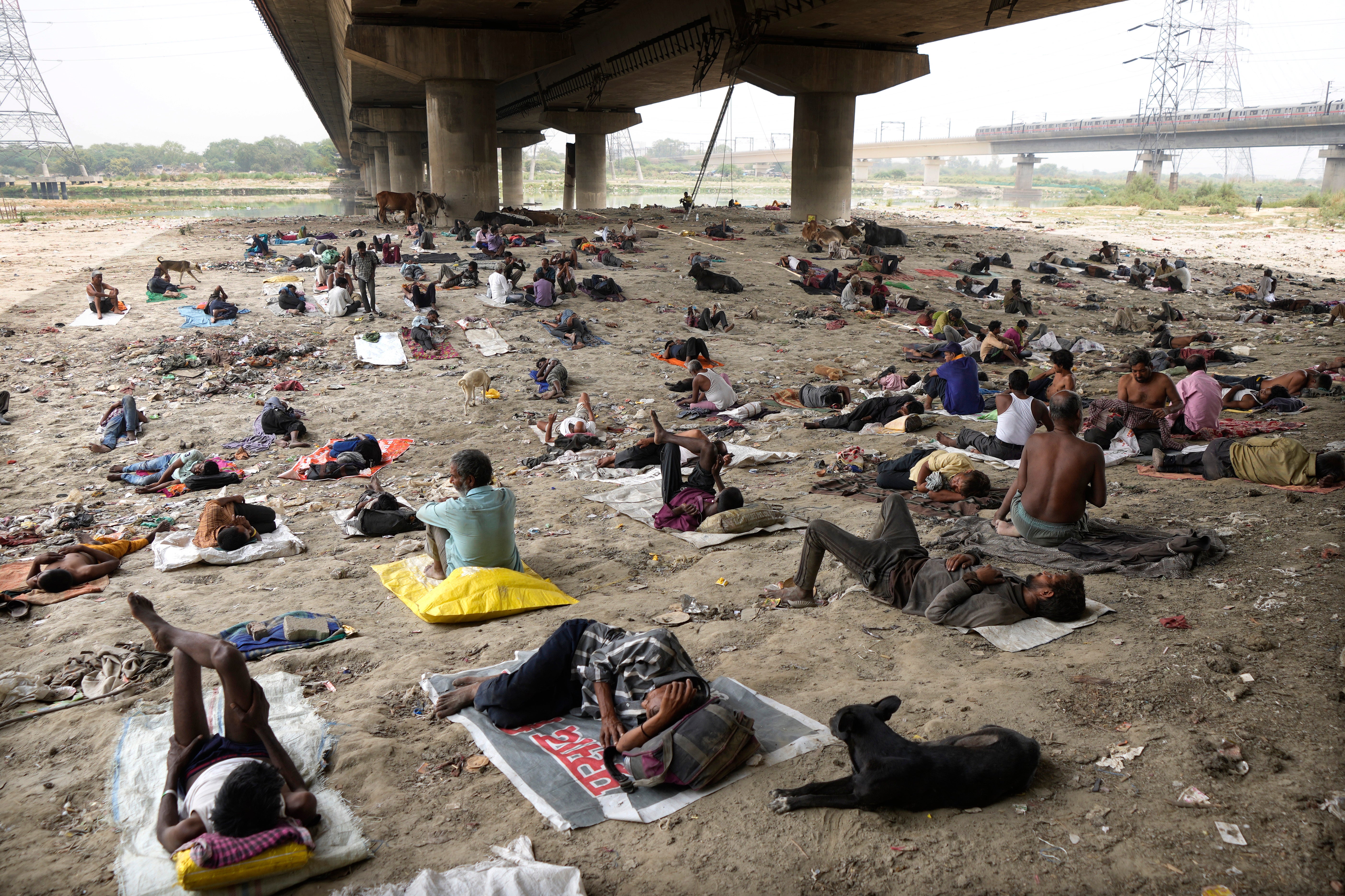 Homeless people sleep in the shade of an overpass to beat a heat wave in New Delhi