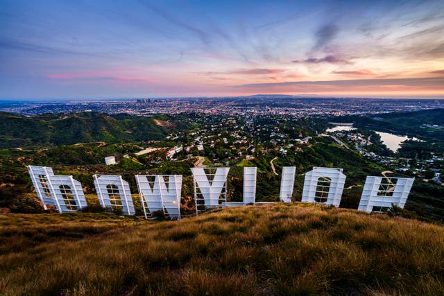 <p>Sunset casts a pink glow over the Los Angeles skyline as seen from behind the famous Hollywood sign Wednesday evening, March 8, 2023</p>