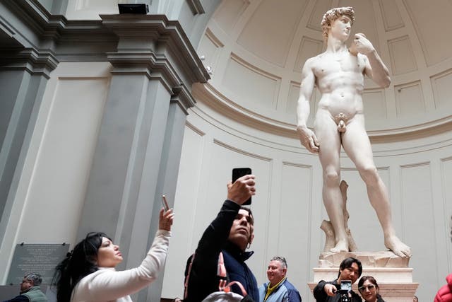 <p>Tourists take photos in front of Michelangelo’s David statue in the Accademia Gallery in Florence, Italy</p>