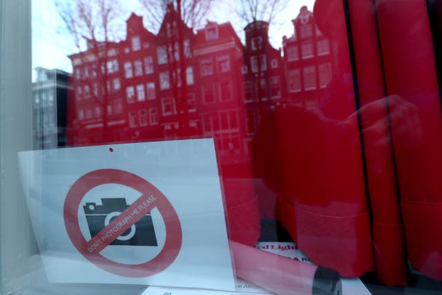 <p>A sign in a brothel window in Amsterdam asks tourists not to take pictures</p>
