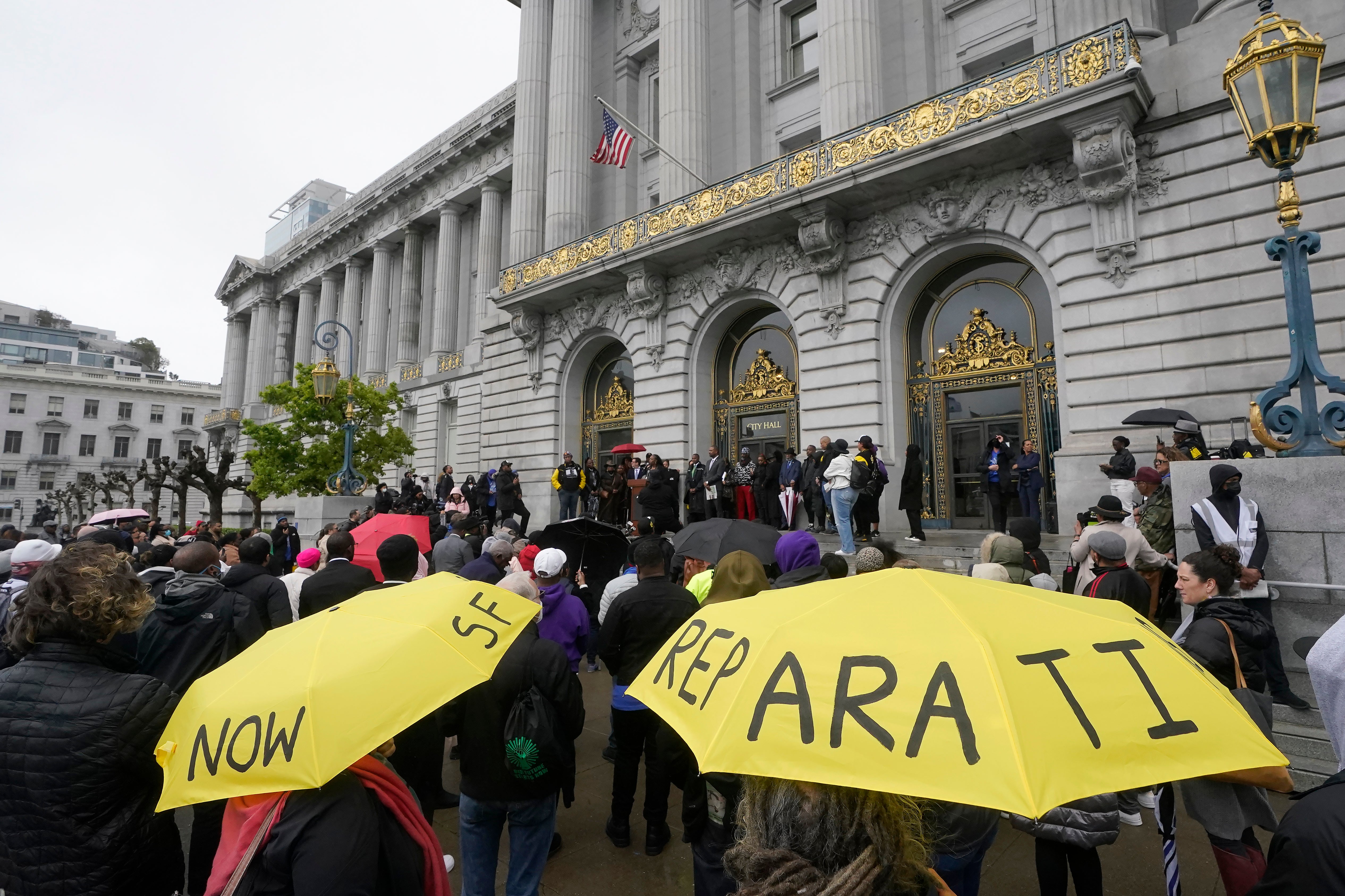 A crowd listens to speakers at a reparations rally outside of City Hall in San Francisco on 14 March 2023