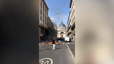 French pension reform: Passerby casually strolls next to fire lit by protesters