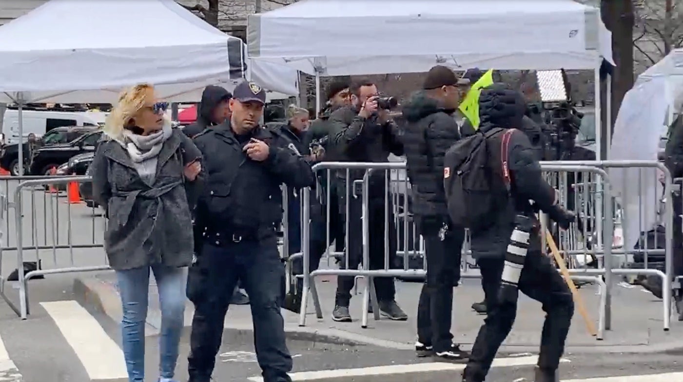 The woman is led away by officers after she pulled a knife outside Manhattan Criminal Court