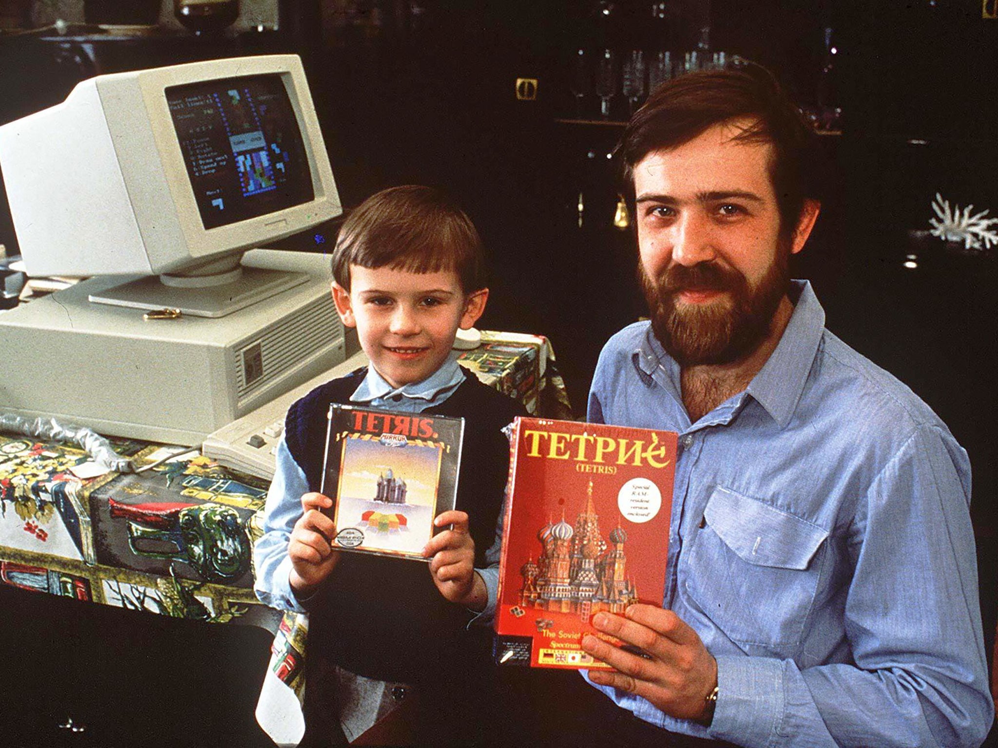 Alexey Pajitnov and one of his sons pose with copies of Tetris in 1989