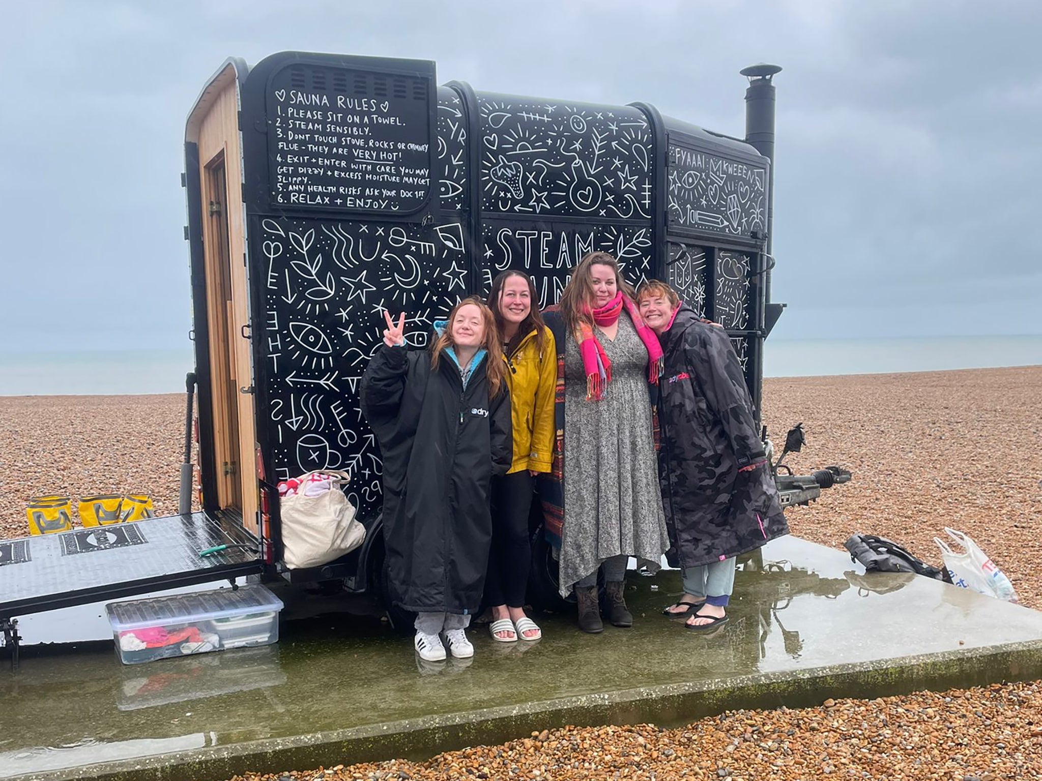 Helen (far right) with friends at a beach sauna on a rainy day in Folkestone